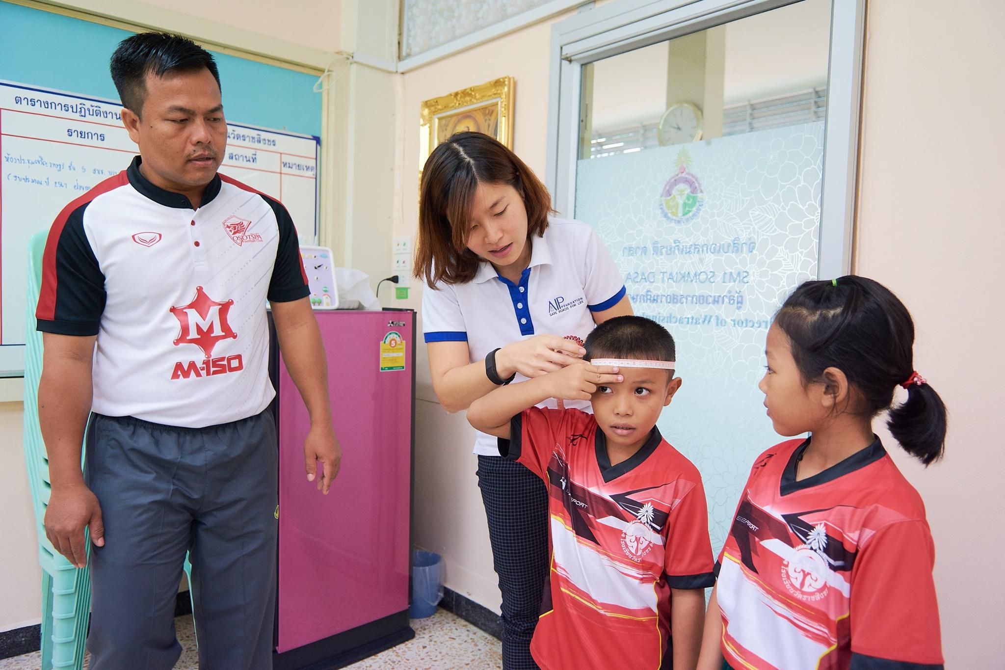 Two students at Wat Rachasingkorn Primary School in Bangkok are fitted for new helmets.