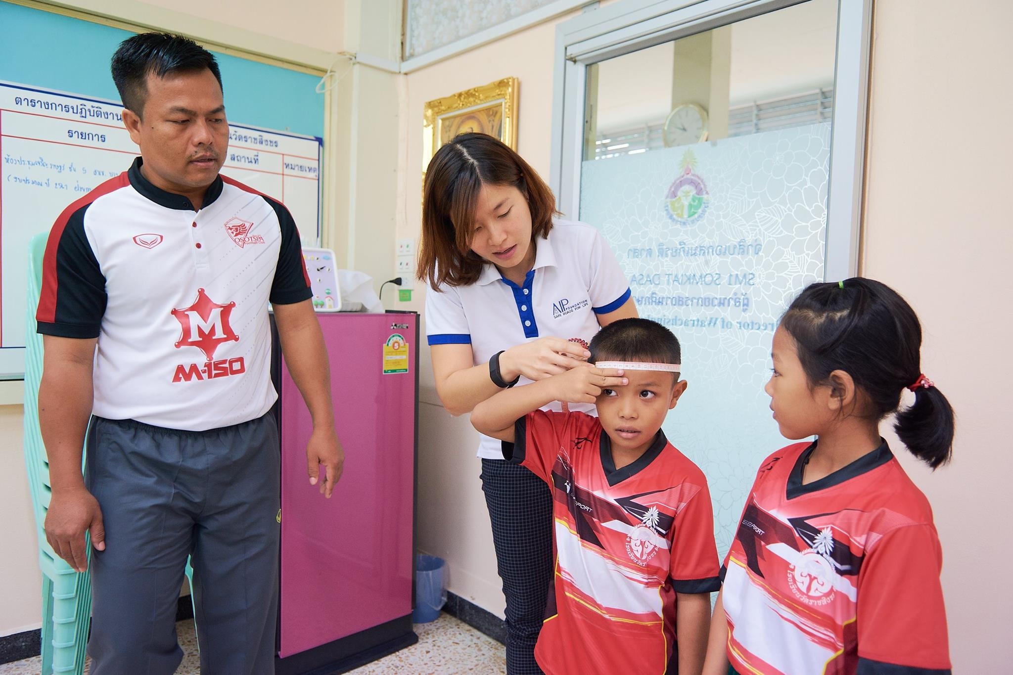 Two students at Wat Rachasingkorn Primary School in Bangkok are fitted for new helmets.