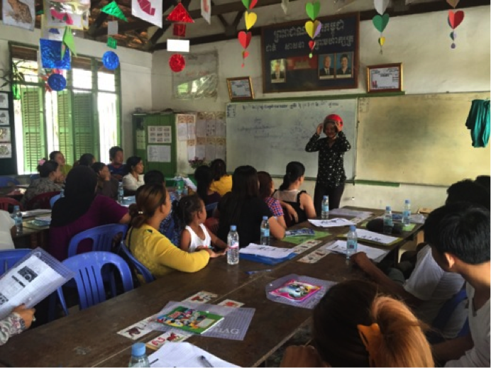 A training course leader demonstrates proper helmet use to a crowd of parents and their children.