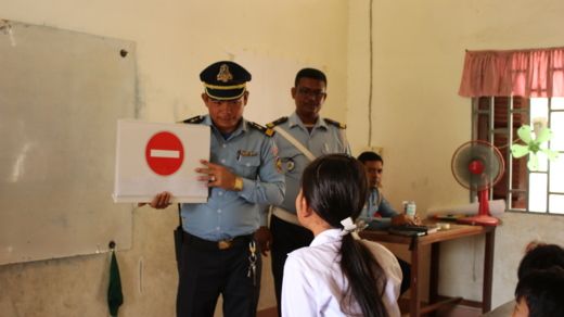 Police officer teaches important road safety signs to a student at Veal Vong Primary School.