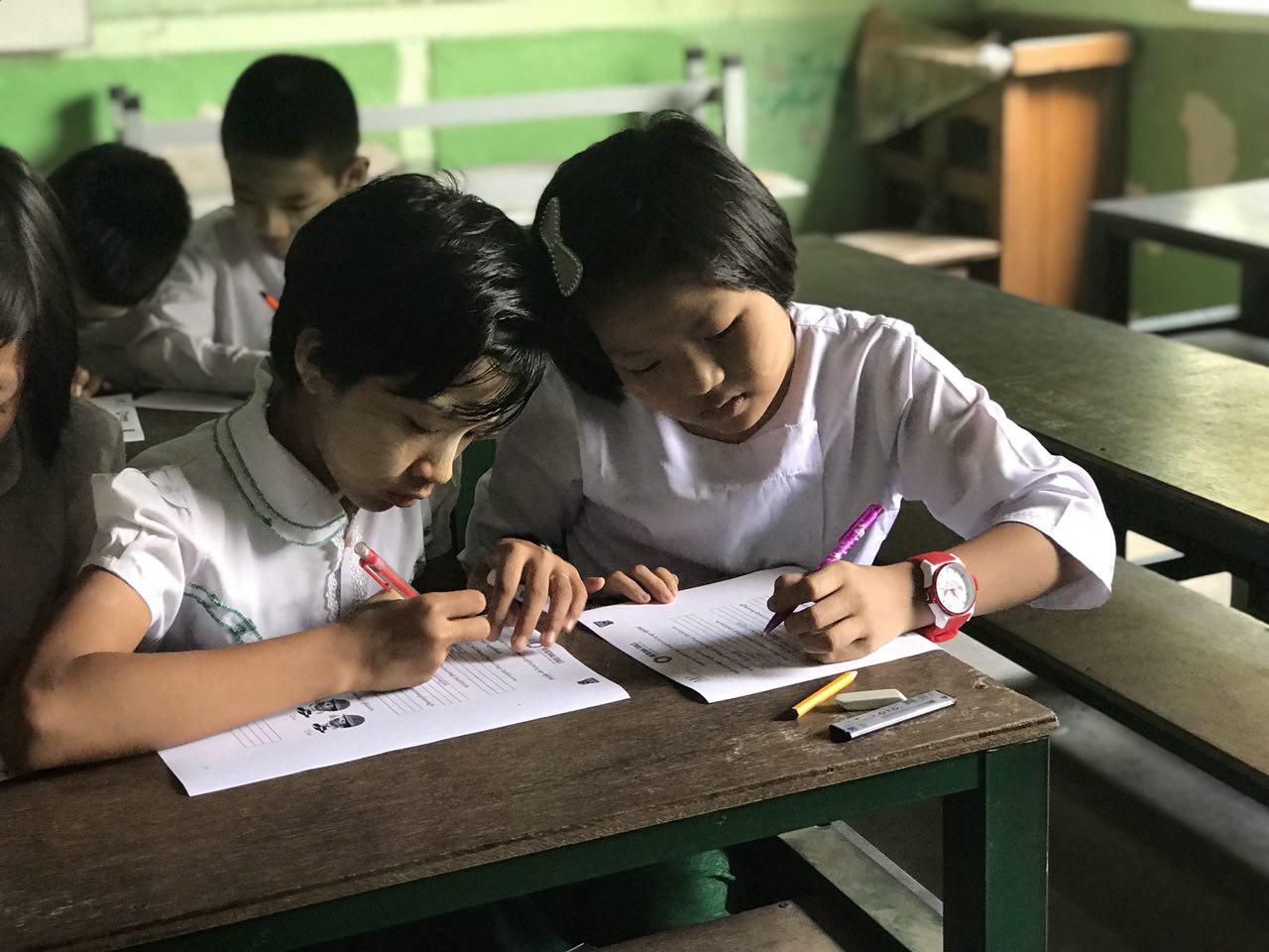 Students from a new program school in Mandalay, Myanmar participate in a baseline knowledge test.