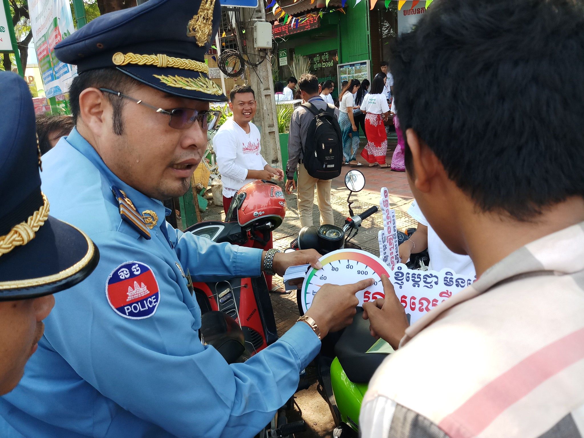 A Phnom Penh police officer providing safe driving tips to a driver.