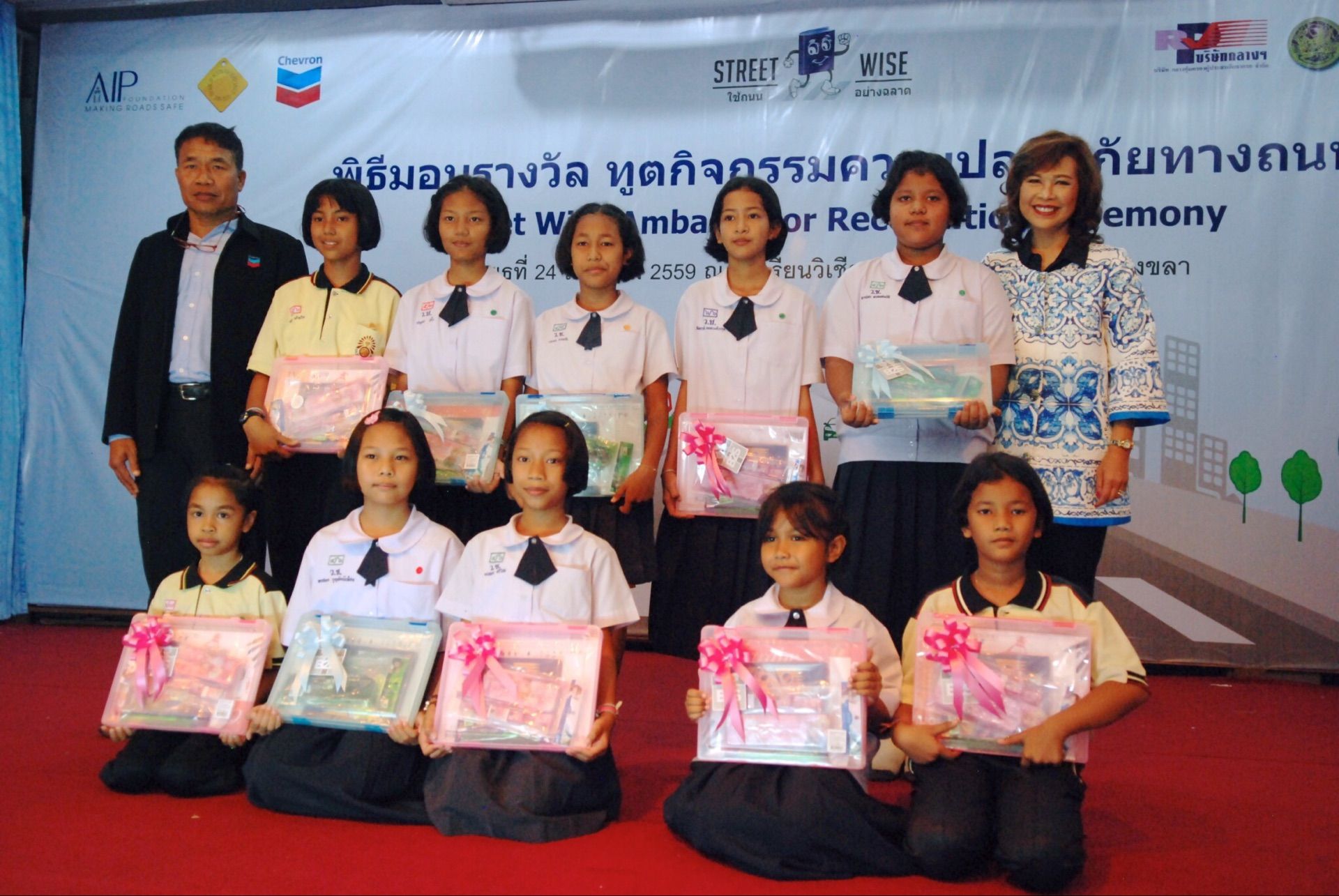 Ms. Ratanawadee Hemniti Winther, Thailand Chairperson of AIP Foundation (right), and Mr. Donnyapinit Pooyoo, Manager of Chevron’s Settapat Center (left), honor a group of students at the event in Songkhla Province.