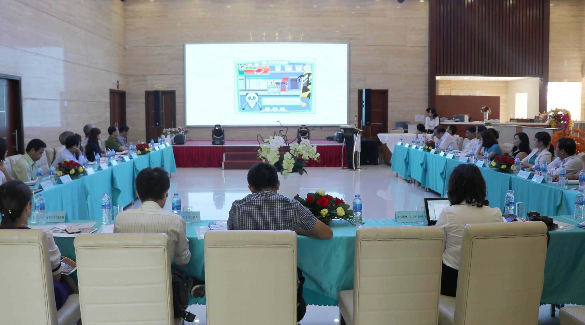 Participants in the orientation workshop listen to a presentation on the proposed plan for road modifications around the schools.