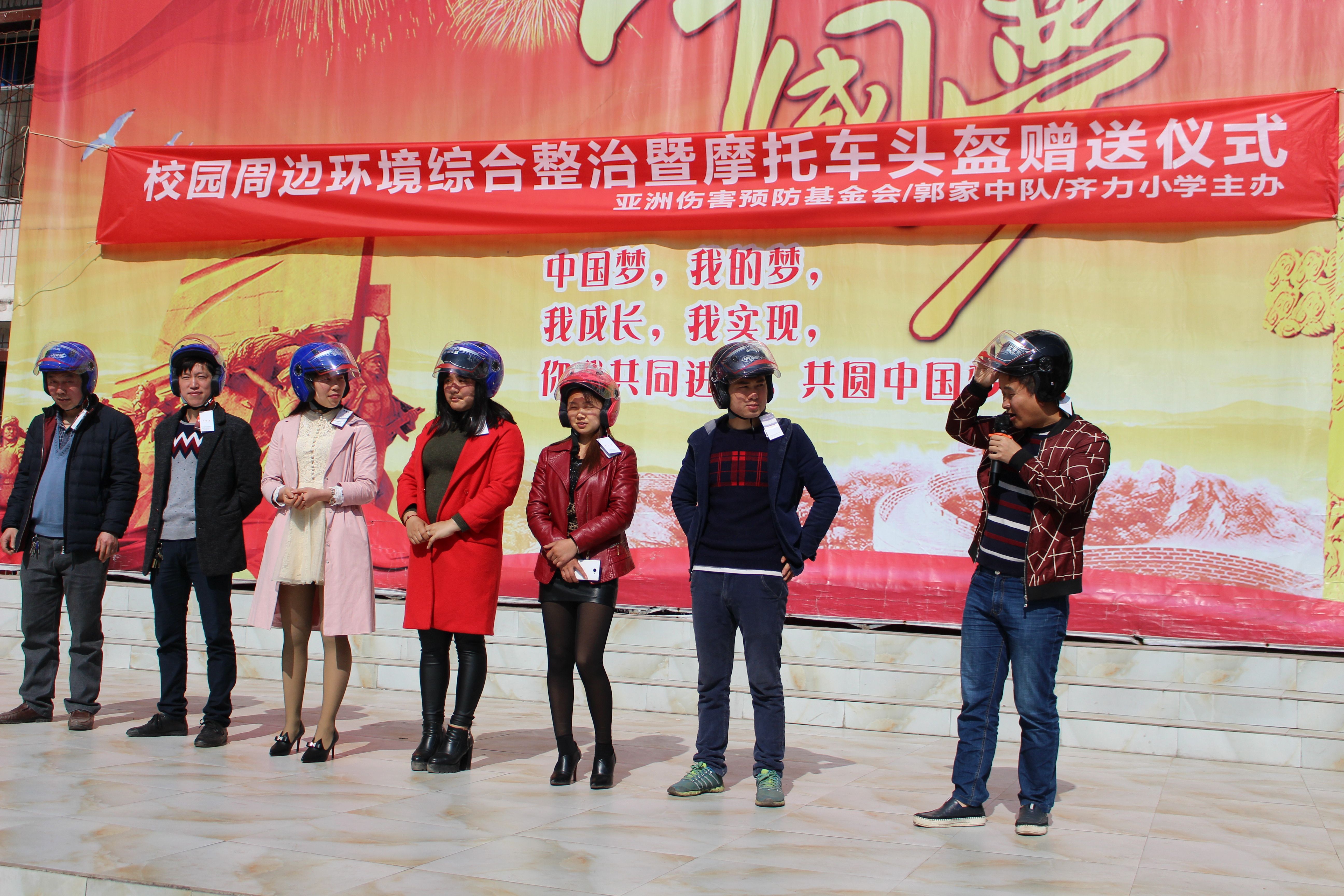 Parents participate in a helmet-wearing demonstration after receiving their new safety equipment.