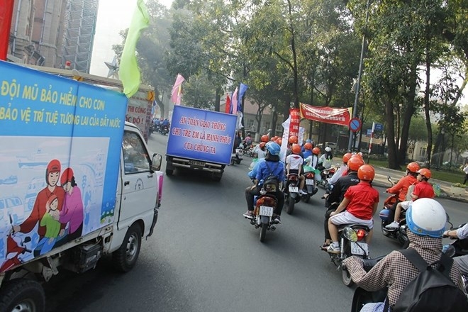 A student holds a sign and wears her new helmet during the road show in Ho Chi Minh City.