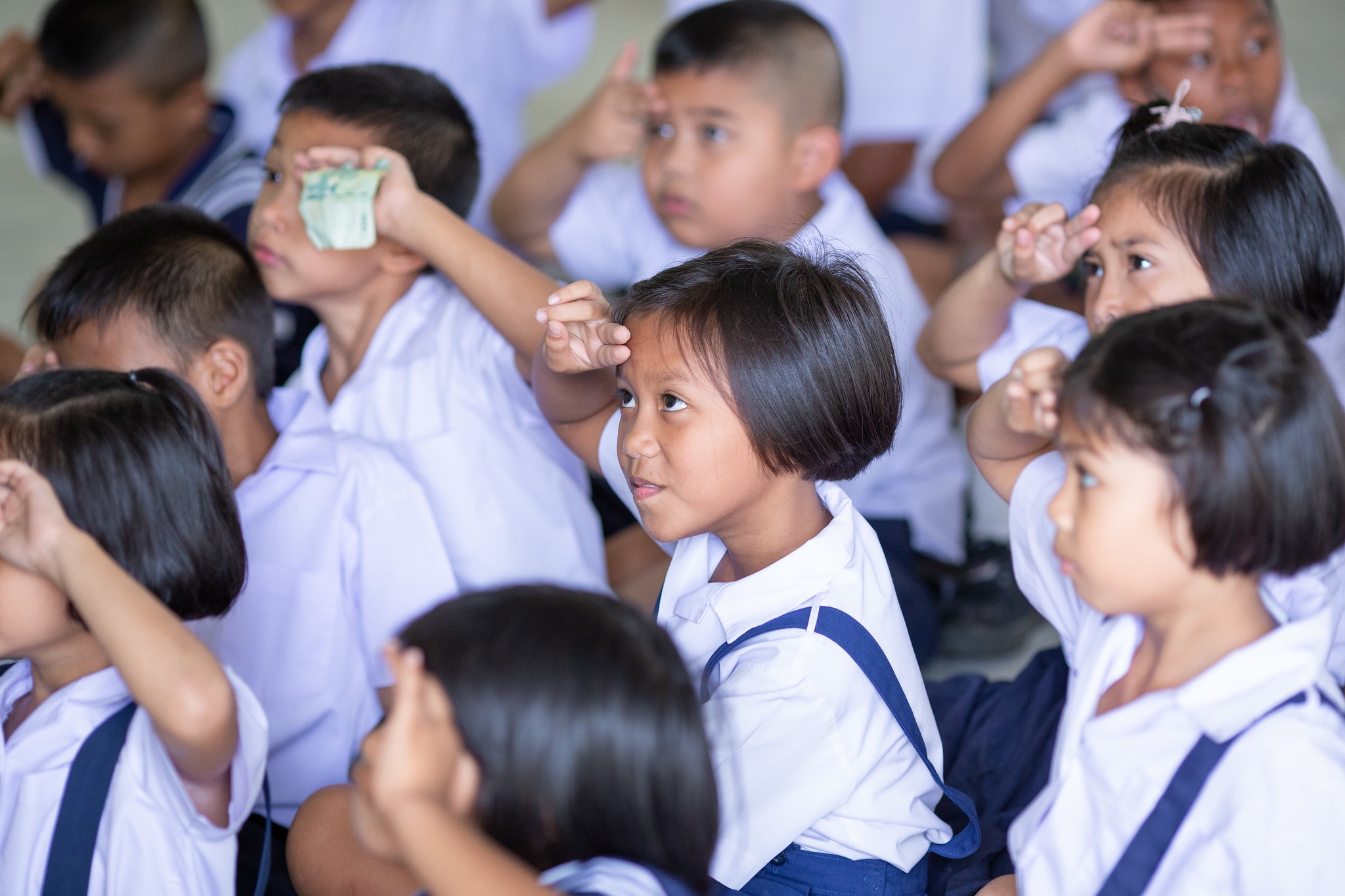 Students practice the “two finger” method for checking that a helmet is worn correctly.