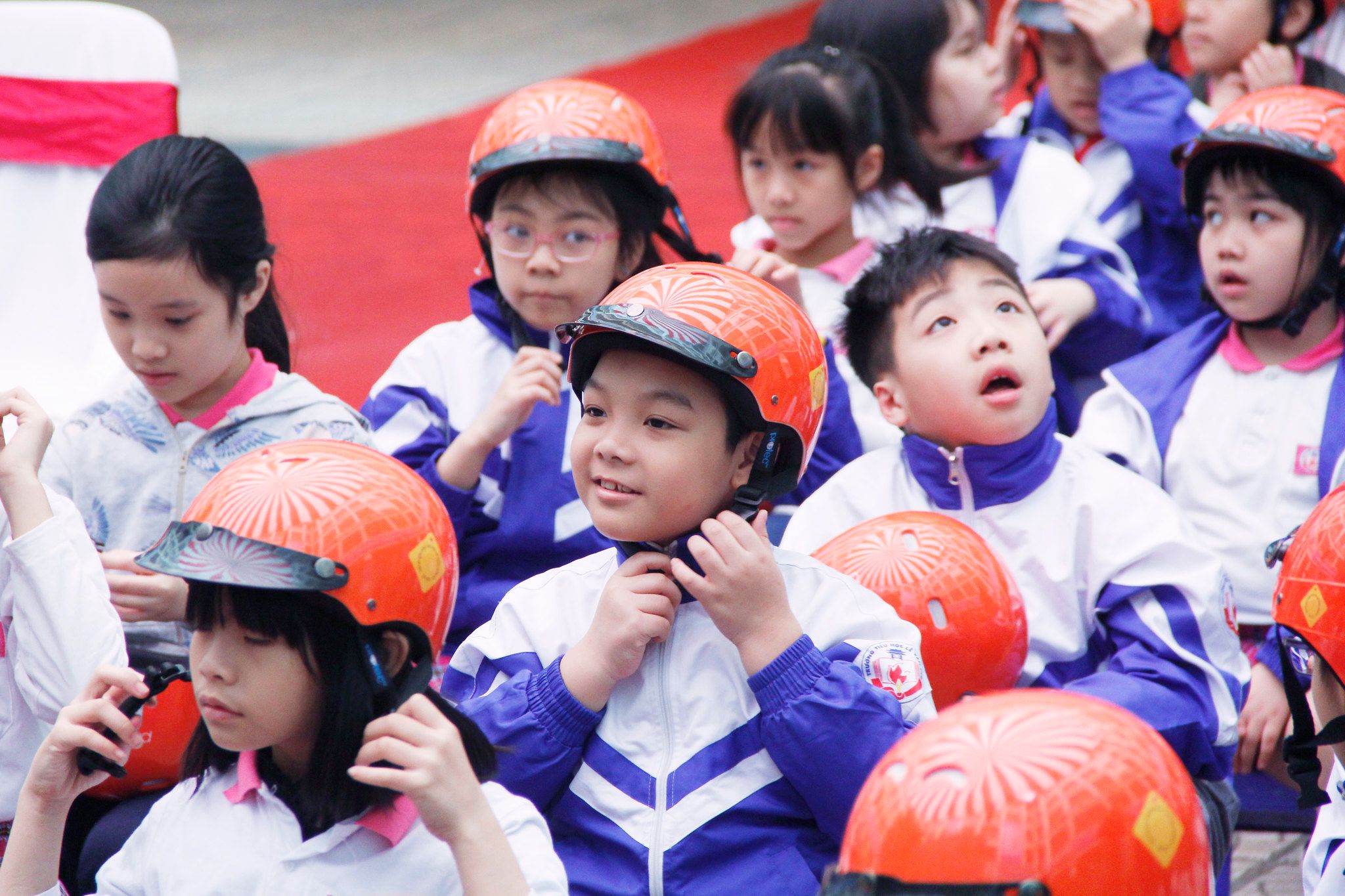 A student follows instructions on how to properly buckle his helmet during a demonstration at the ceremony.