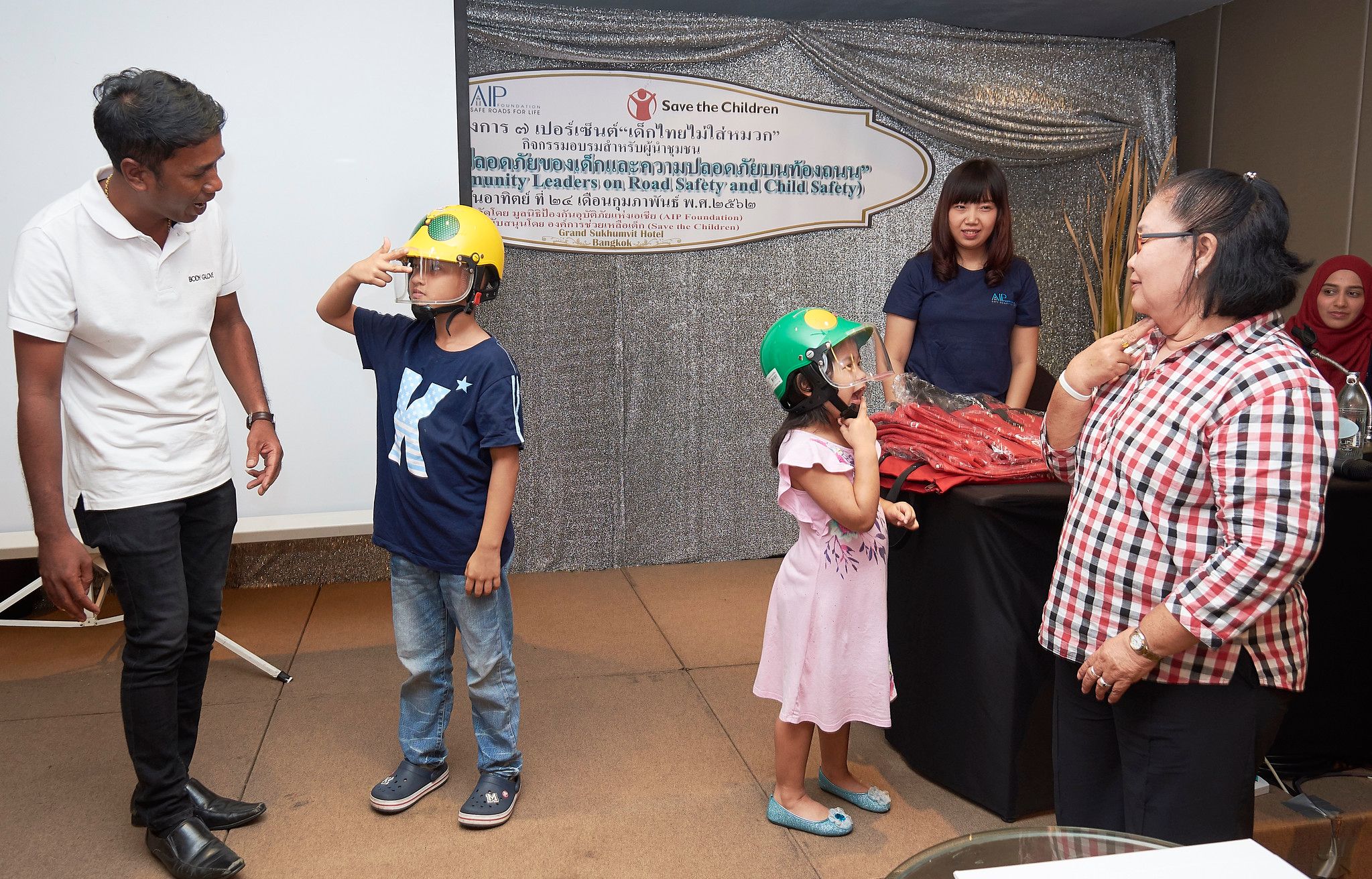 Young students demonstrating the correct way to wear helmets at the training.