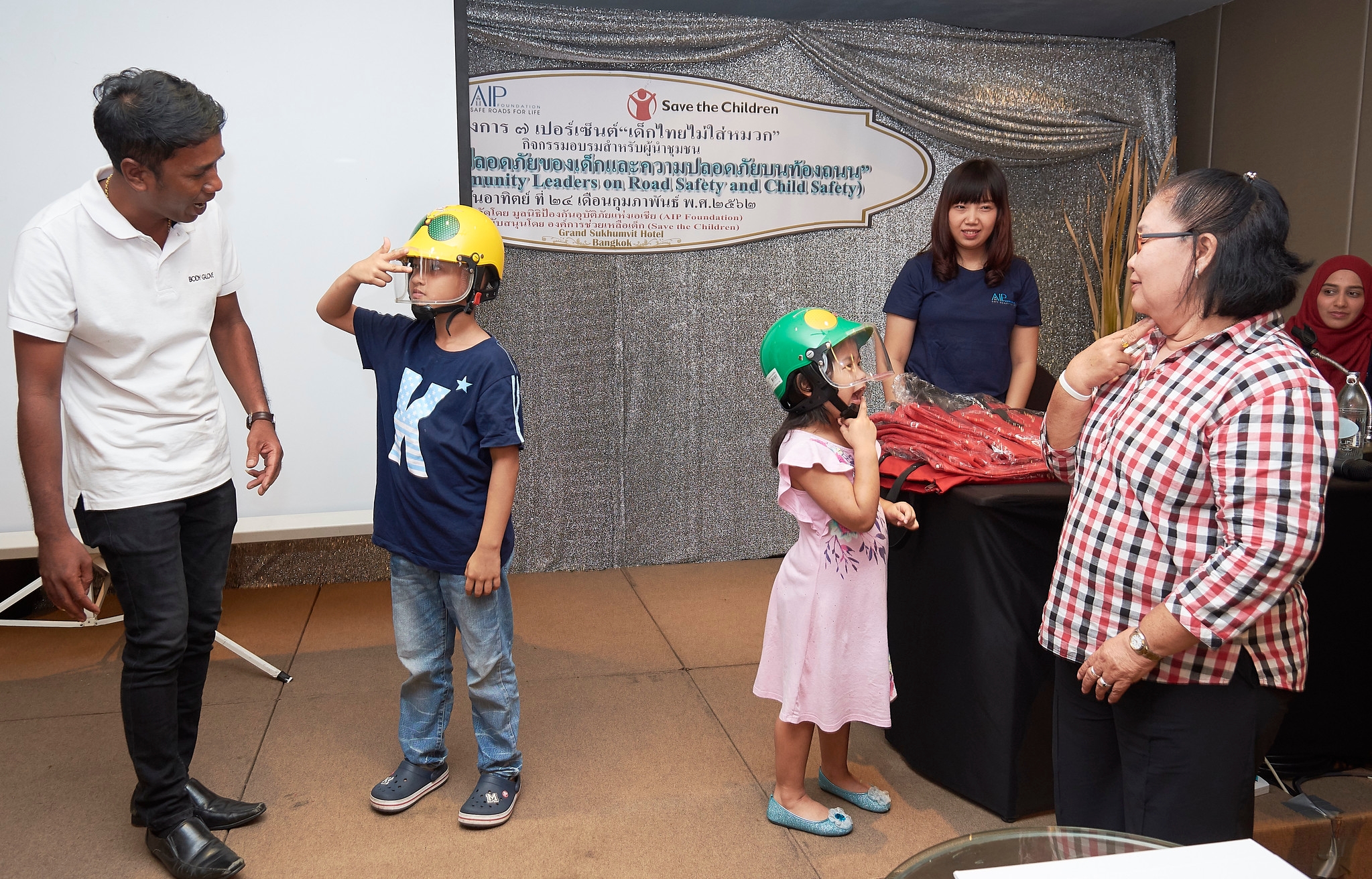 Young students demonstrating the correct way to wear helmets at the training.