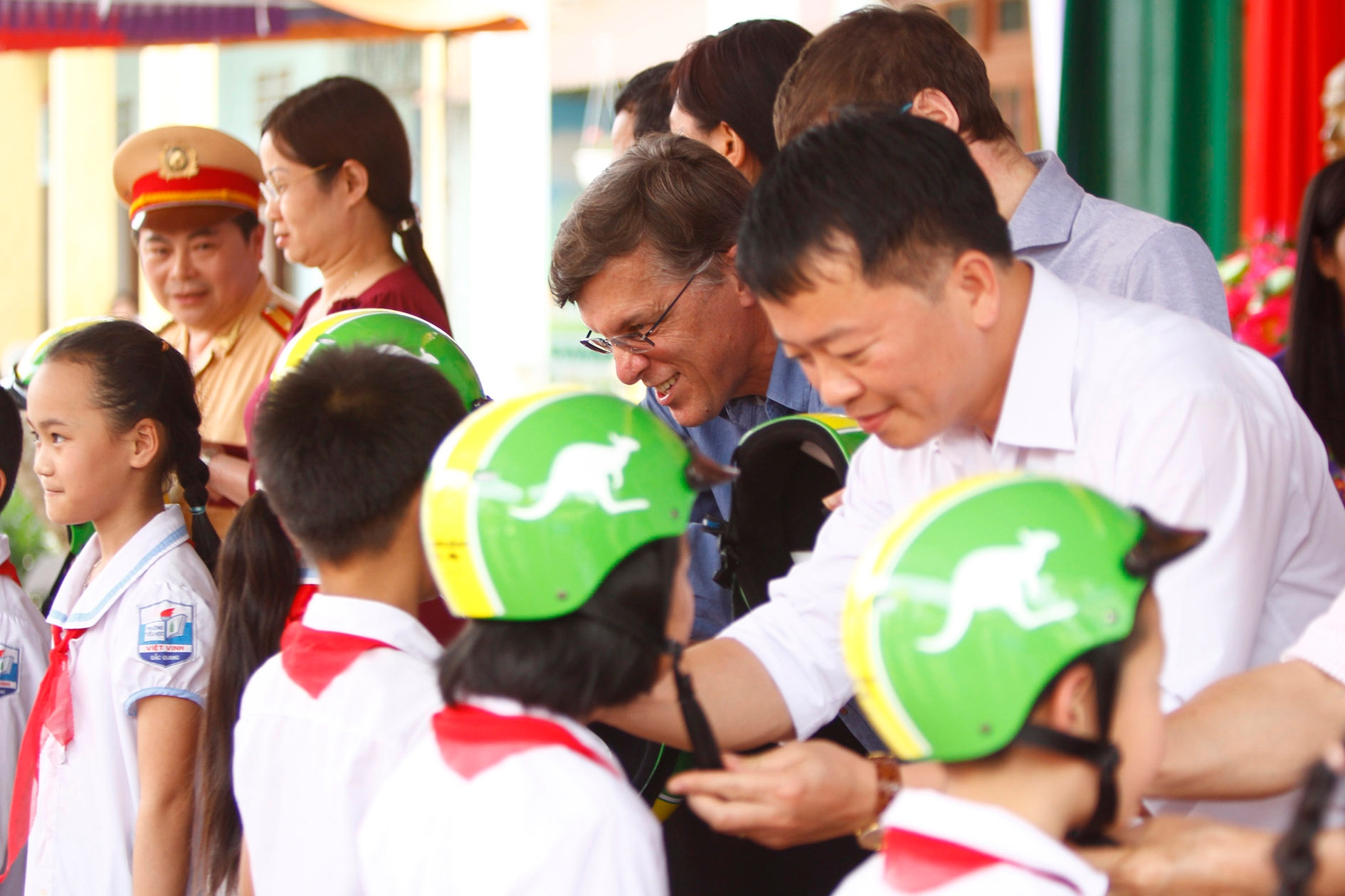 Ambassador Borrowman participates in the helmet donation ceremony and teaches students how to correctly wear their new helmets.