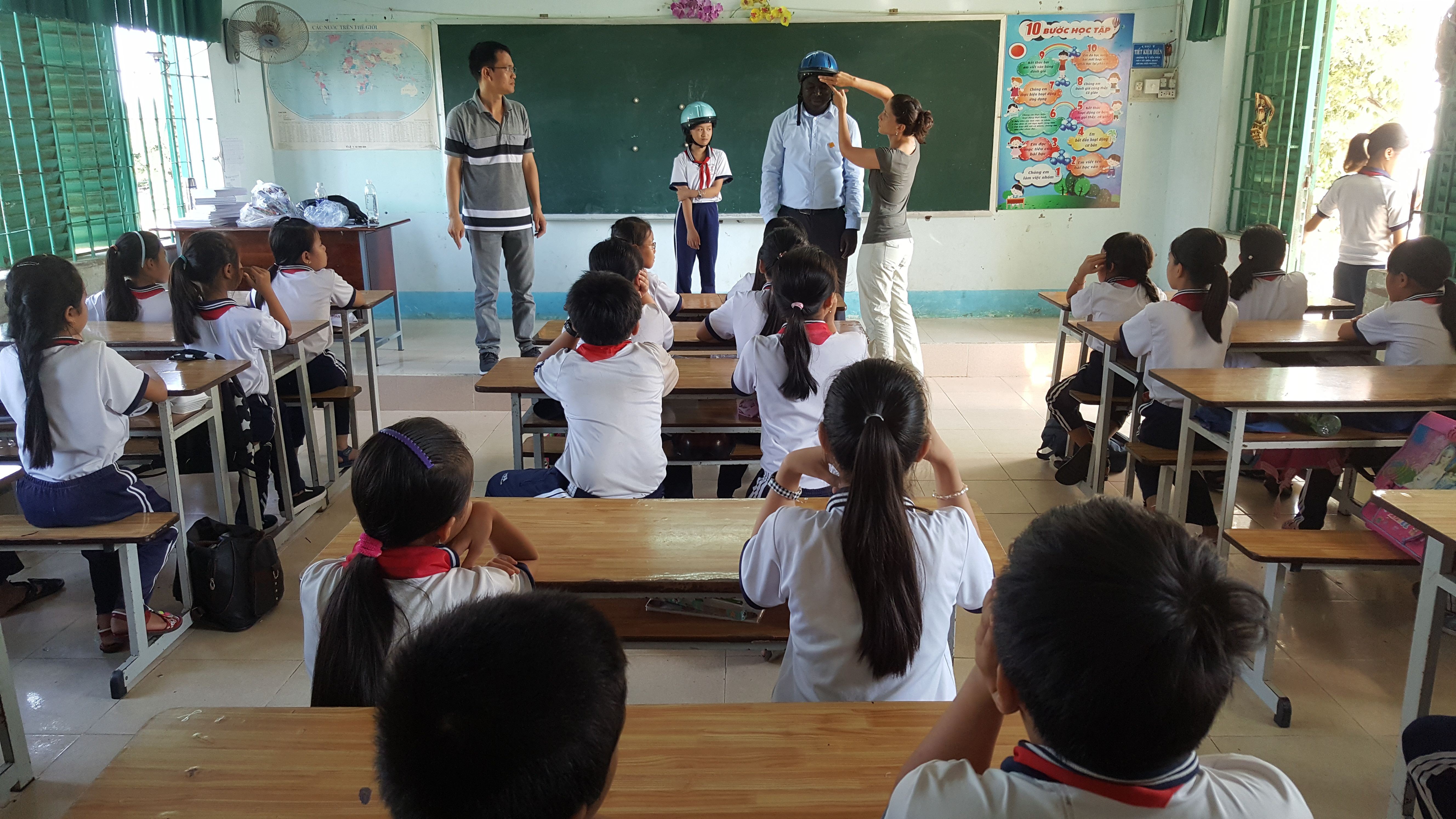 APM Terminals employees teach students at a school in Ba Ria-Vung Tau Province how to properly wear a helmet.