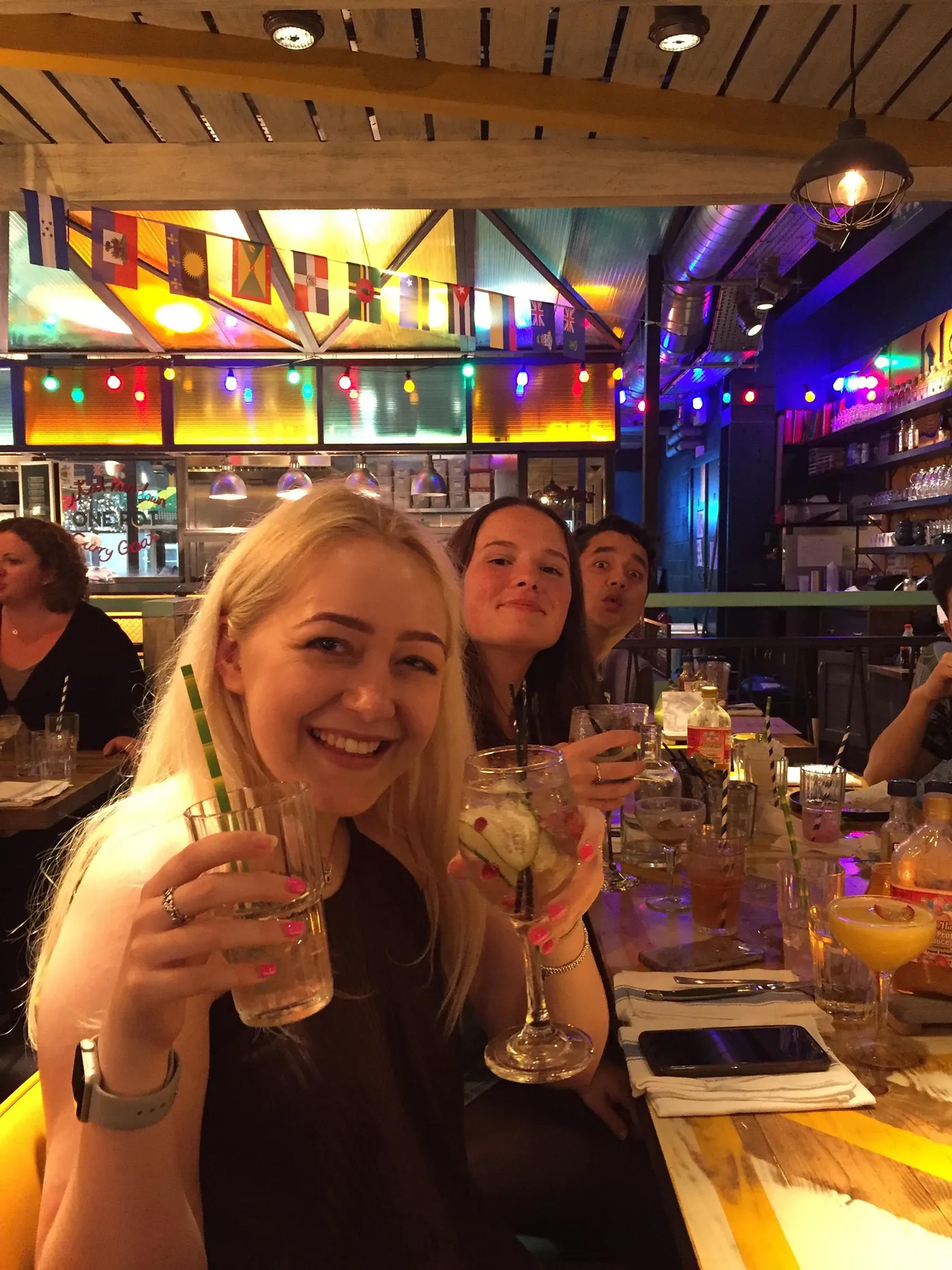 Lauren smiling holding up drinks