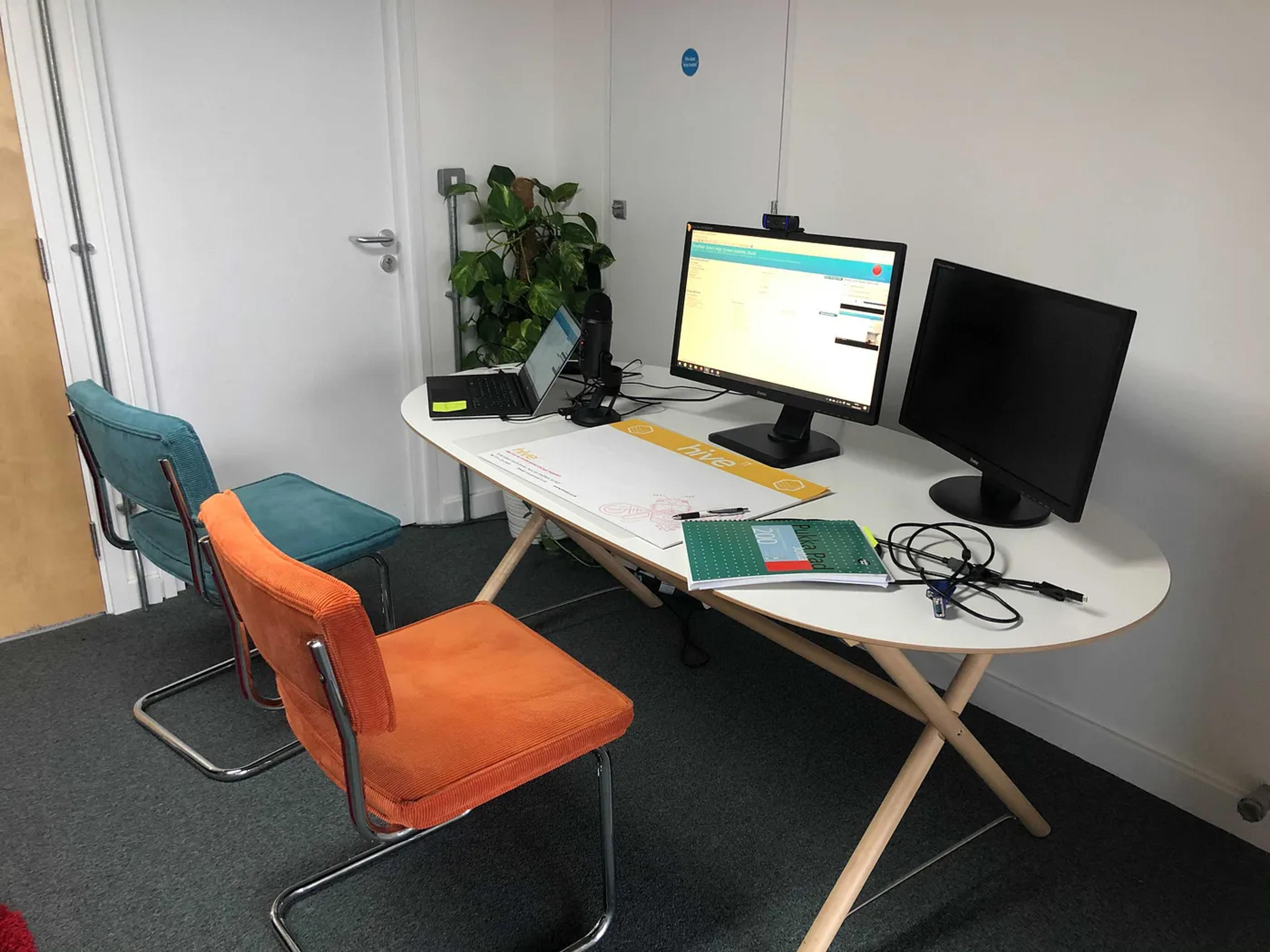 Picture of a table and chairs with a laptop on the desk