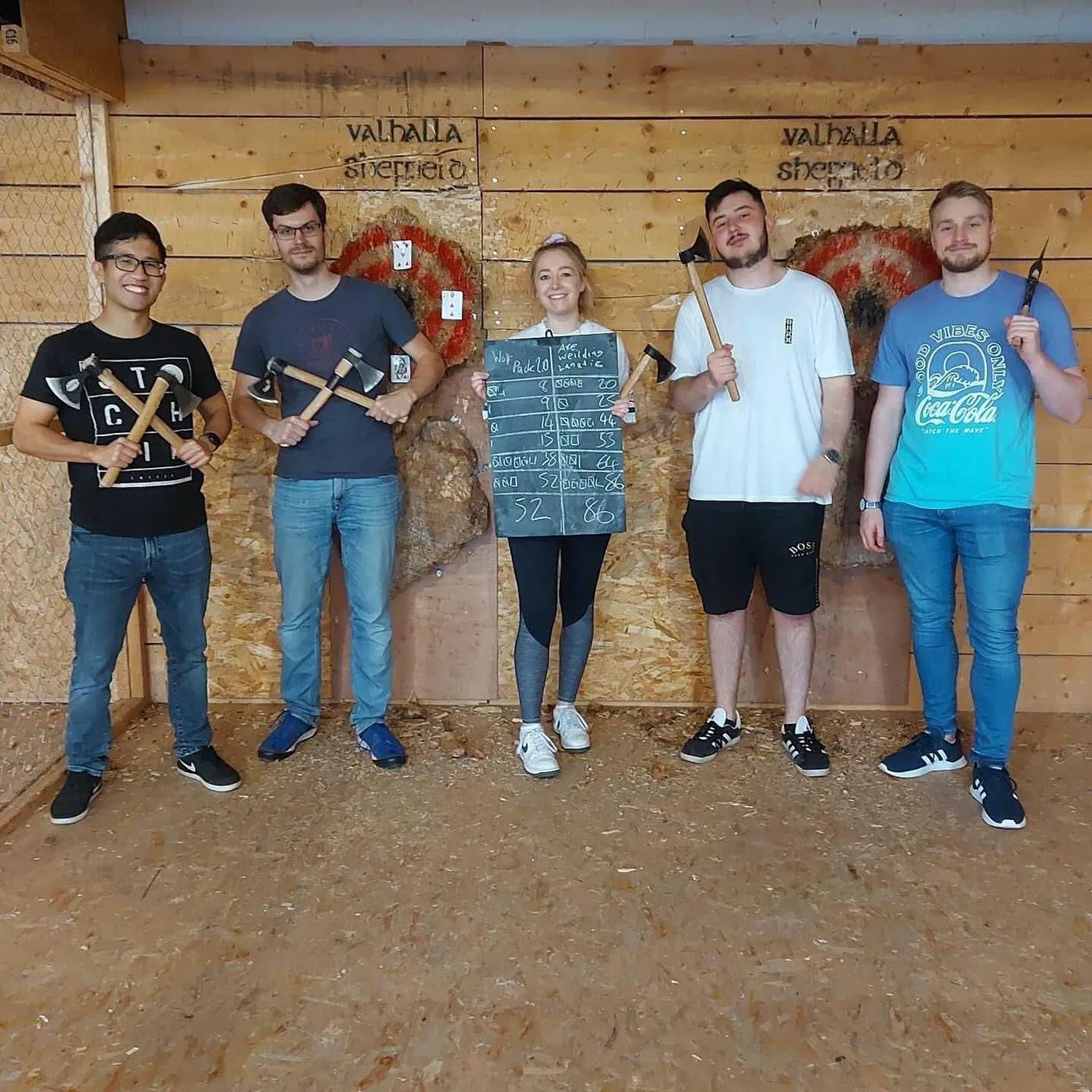 Hive IT team members playing axe throwing and smiling