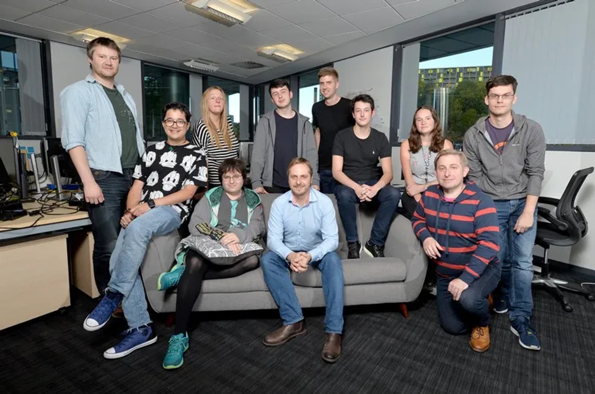 Group of people sat on a couch smiling