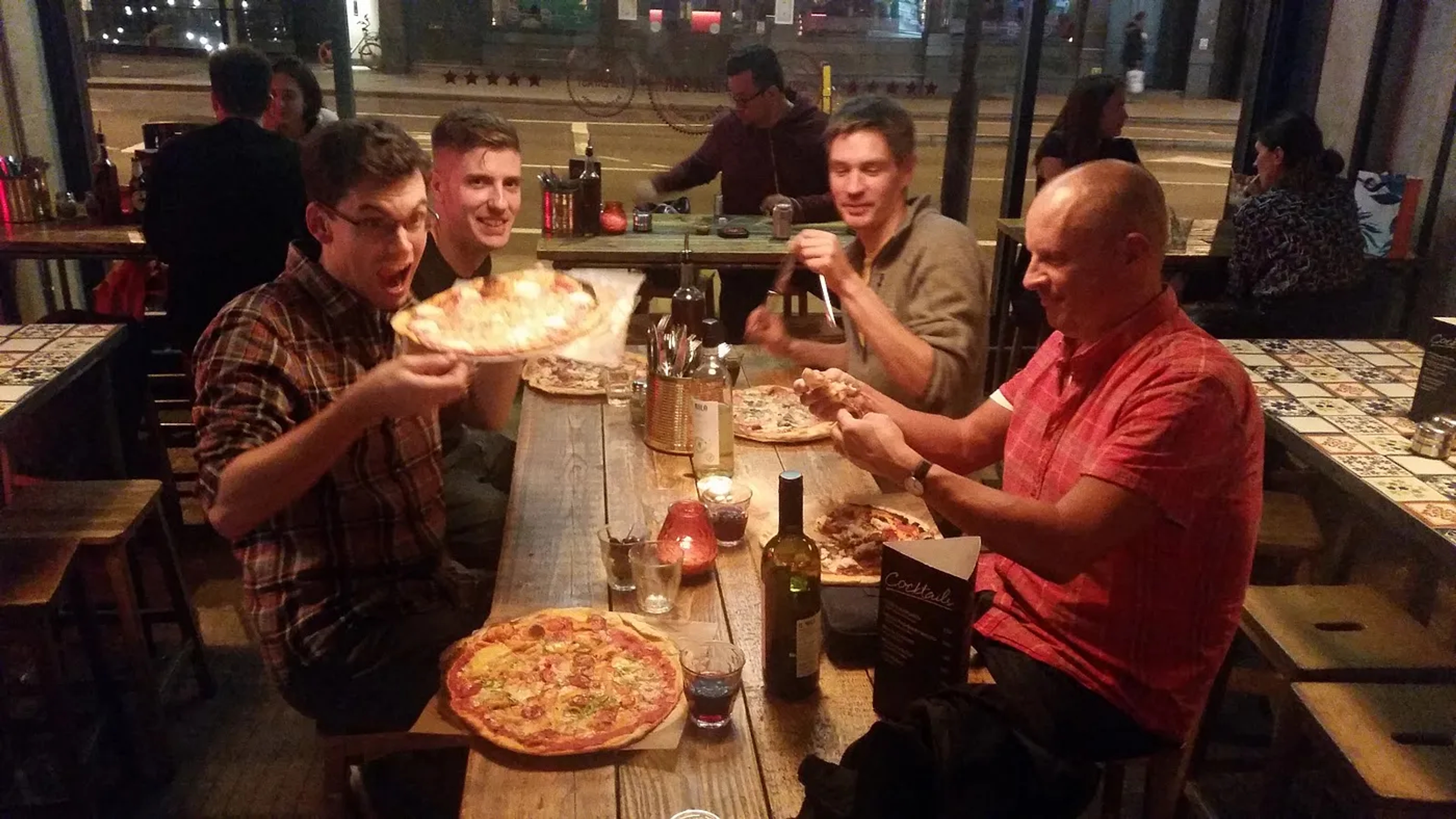 Hive IT team members smiling and enjoying themselves eating pizza