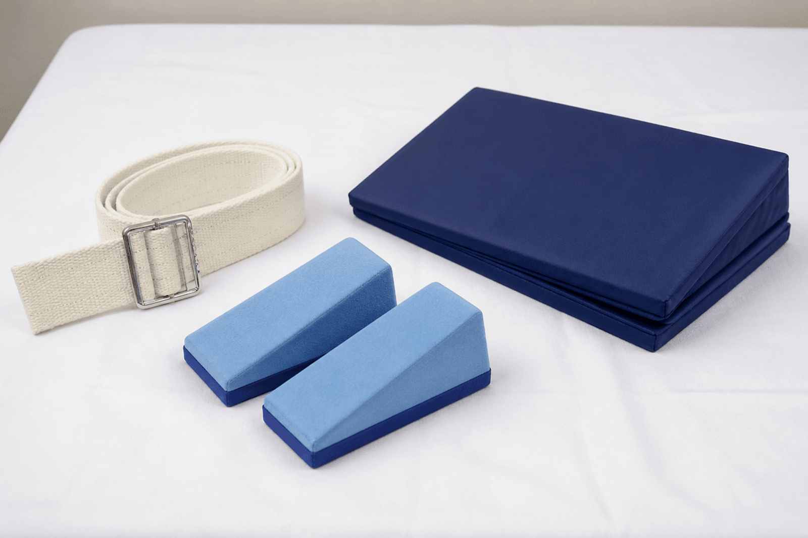 Gait belt, foam heel elevators, and a turning wedge on white linen.