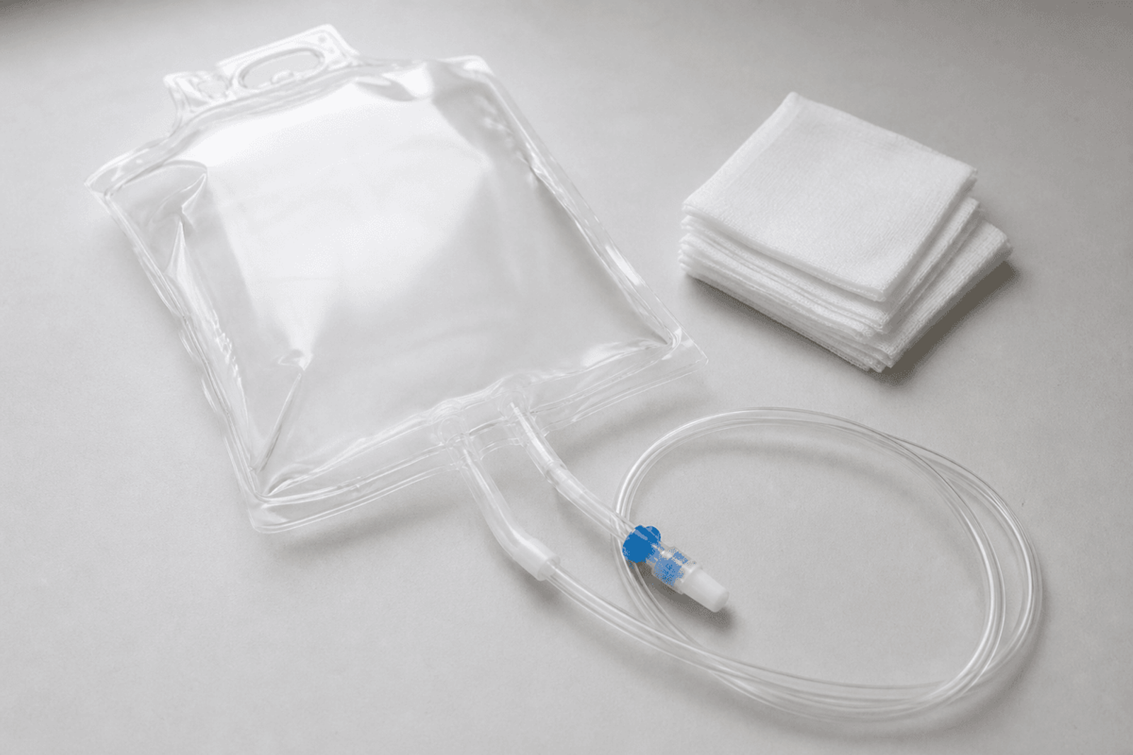 Peritoneal dialysis drain bag, tubing, and sterile gauze on a clean table.