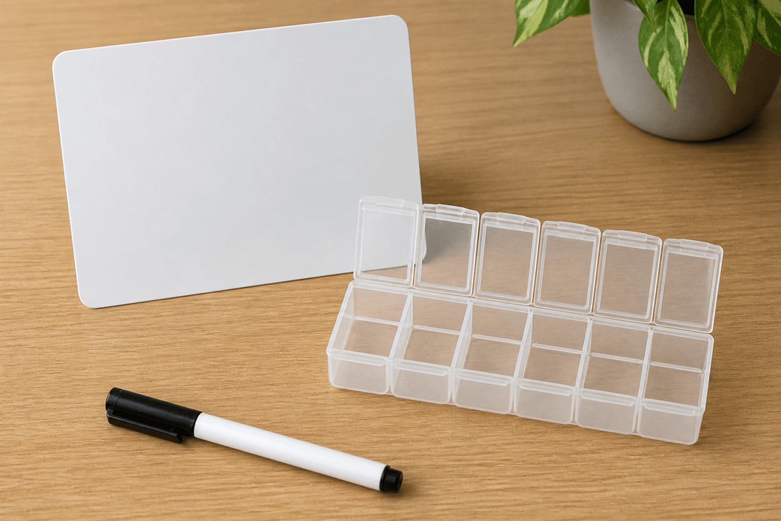 Blank card, marker, and empty pill organizer on a table.