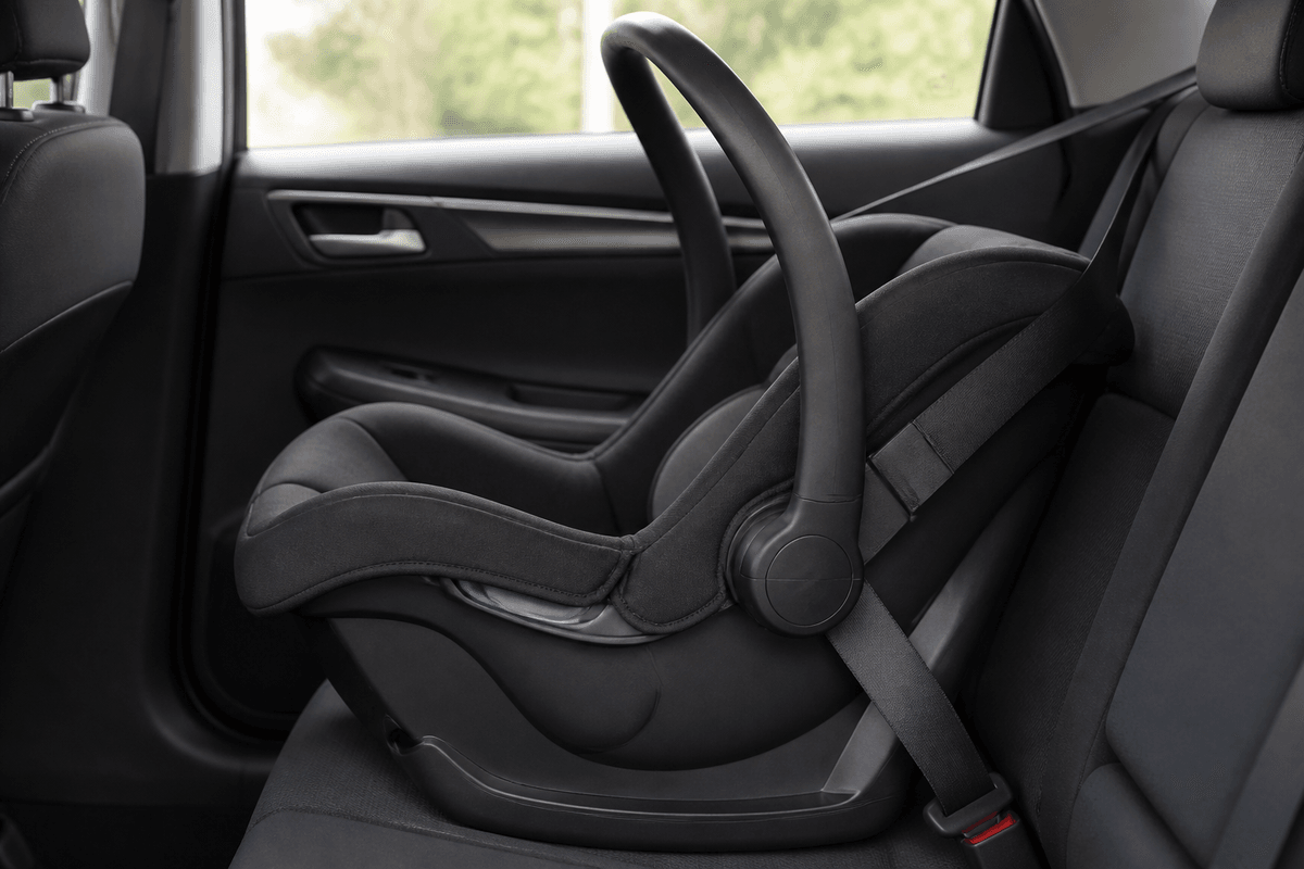Empty rear-facing infant car seat installed in a vehicle back seat.