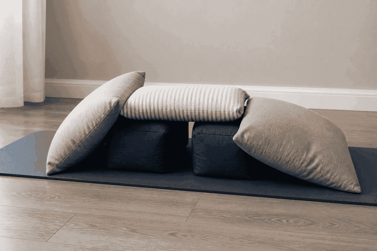 Pillows arranged on a mat to support knee-chest positioning practice.