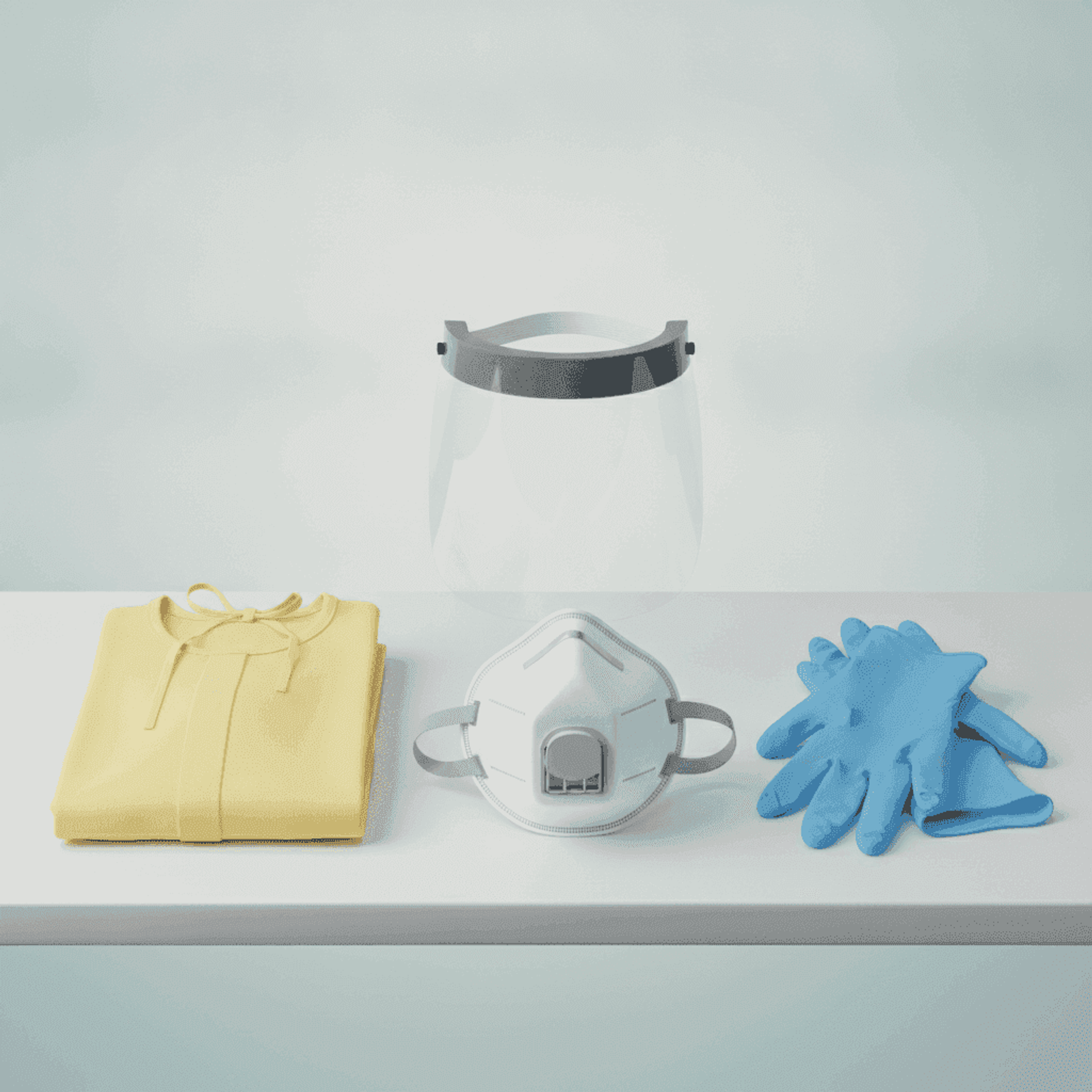 N95 respirator, face shield, isolation gown, and gloves laid flat on a clean table.