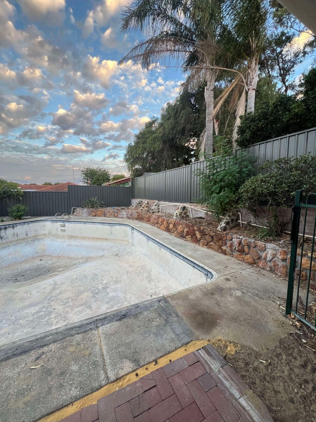 open photo of poolside area showcasing newly built dark fence
