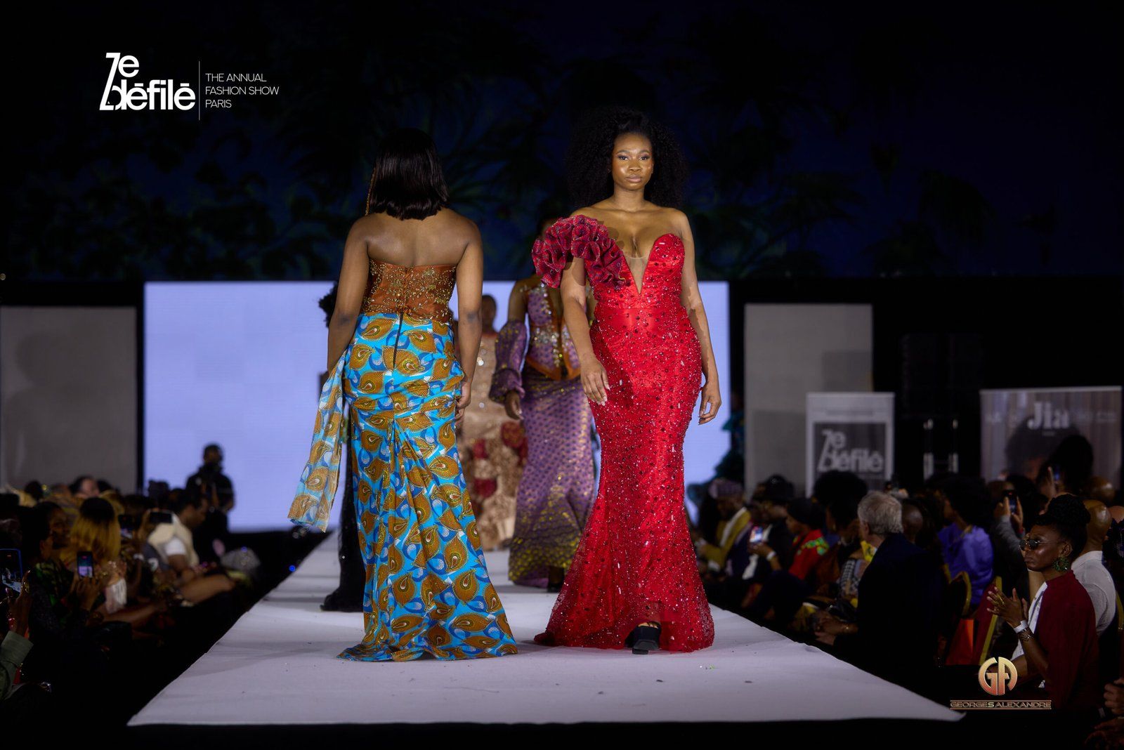 Deux mannequins sur le podium de ZE DÉFILÉ, en robes longues.
