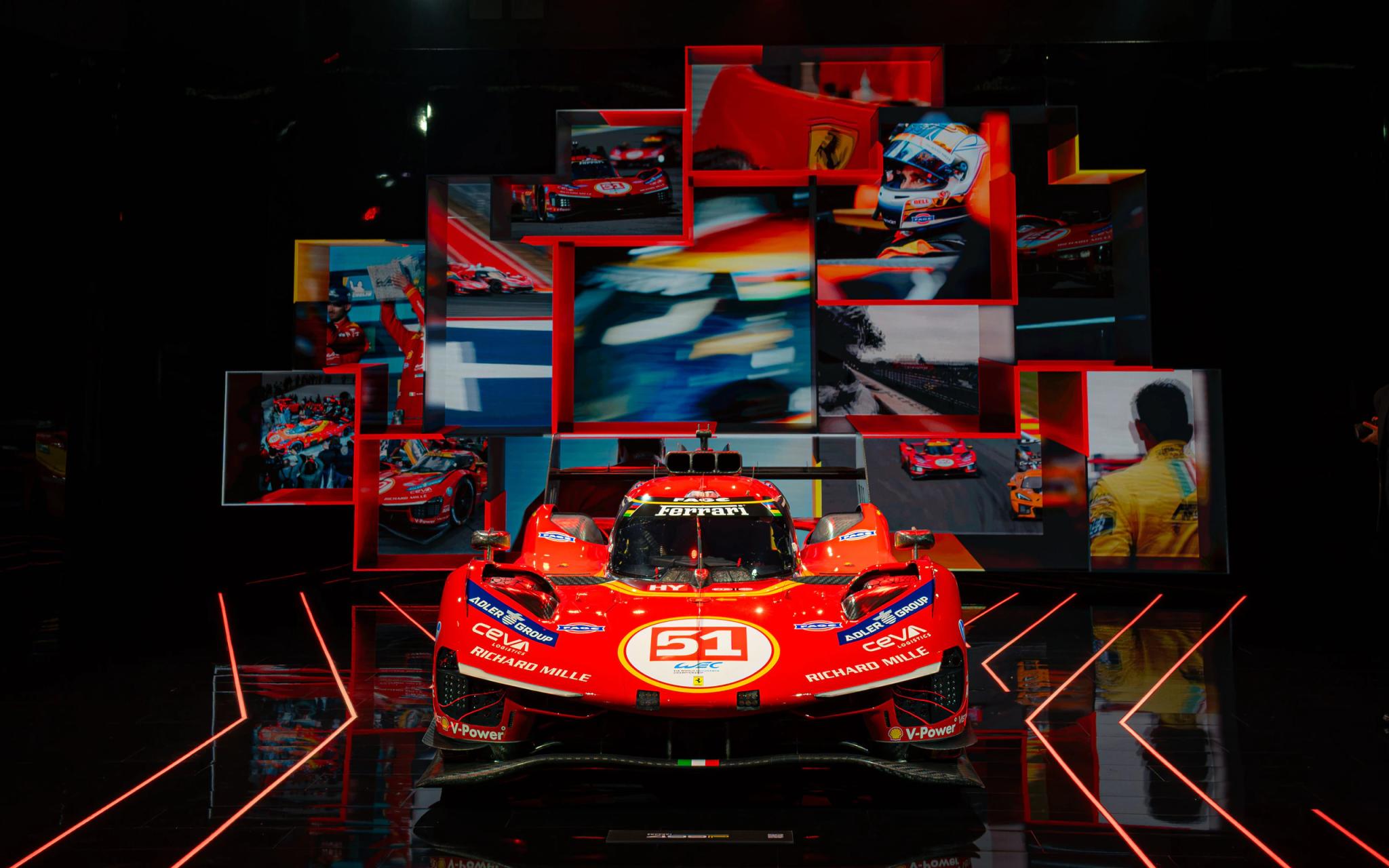 Wall of Ferrari racing photographs above the 499P at Universo Ferrari