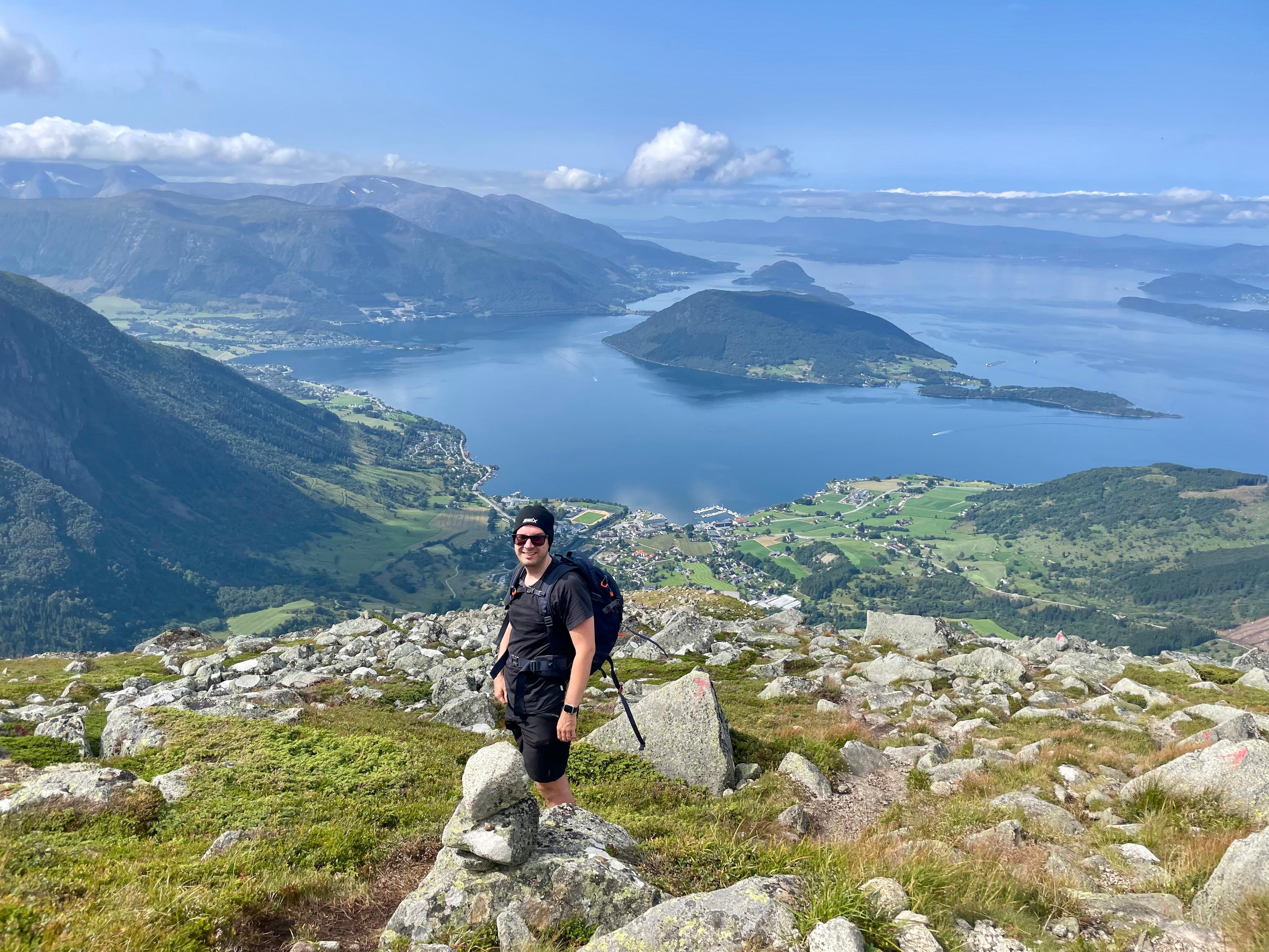 Turgåer på steinete flate ovenfor Rosendal, med fjorden og en øy i bakgrunnen