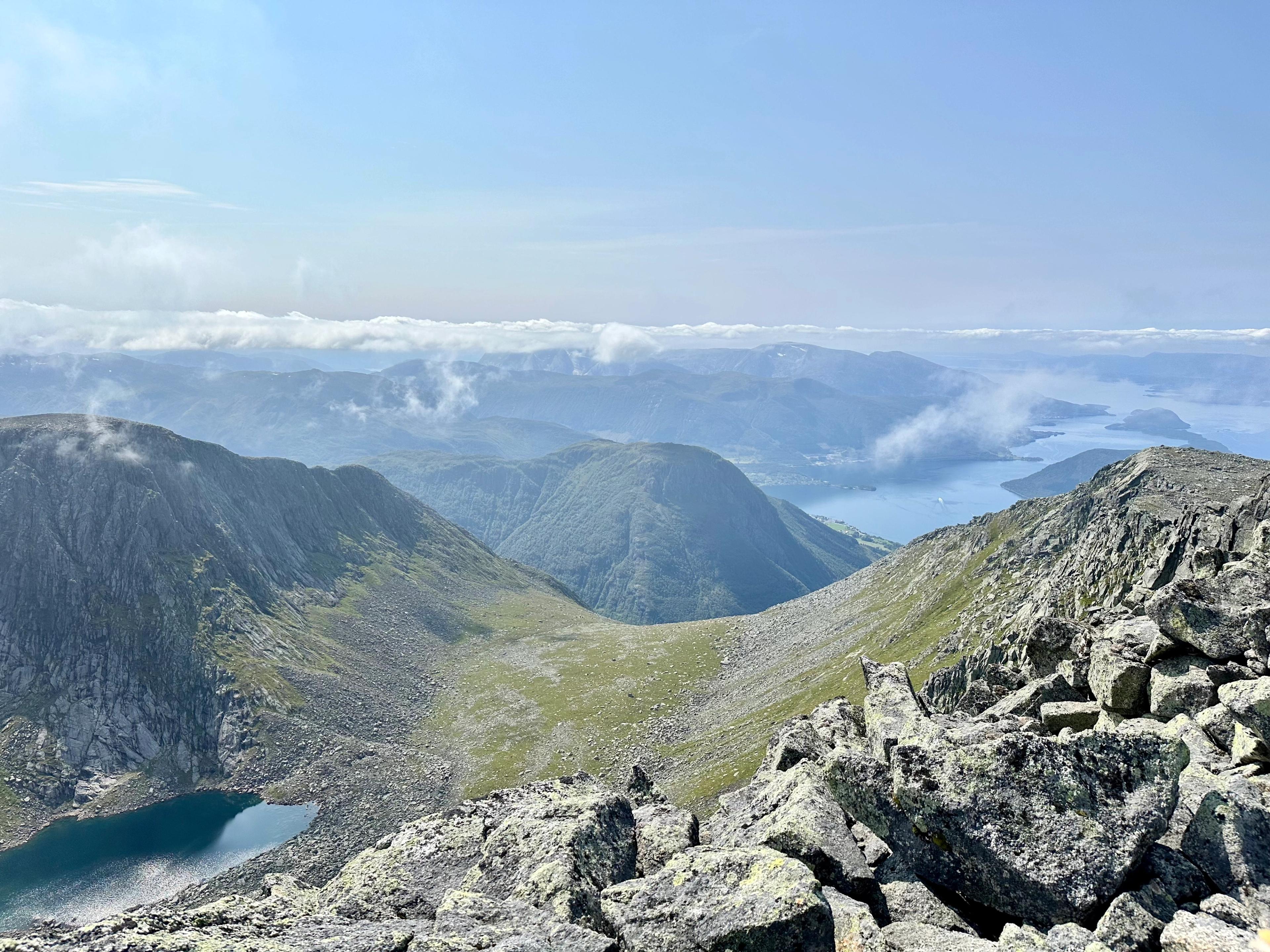 Utsikt fra toppen av Melderskin mot egger, et fjellvann og fjorden i det fjerne