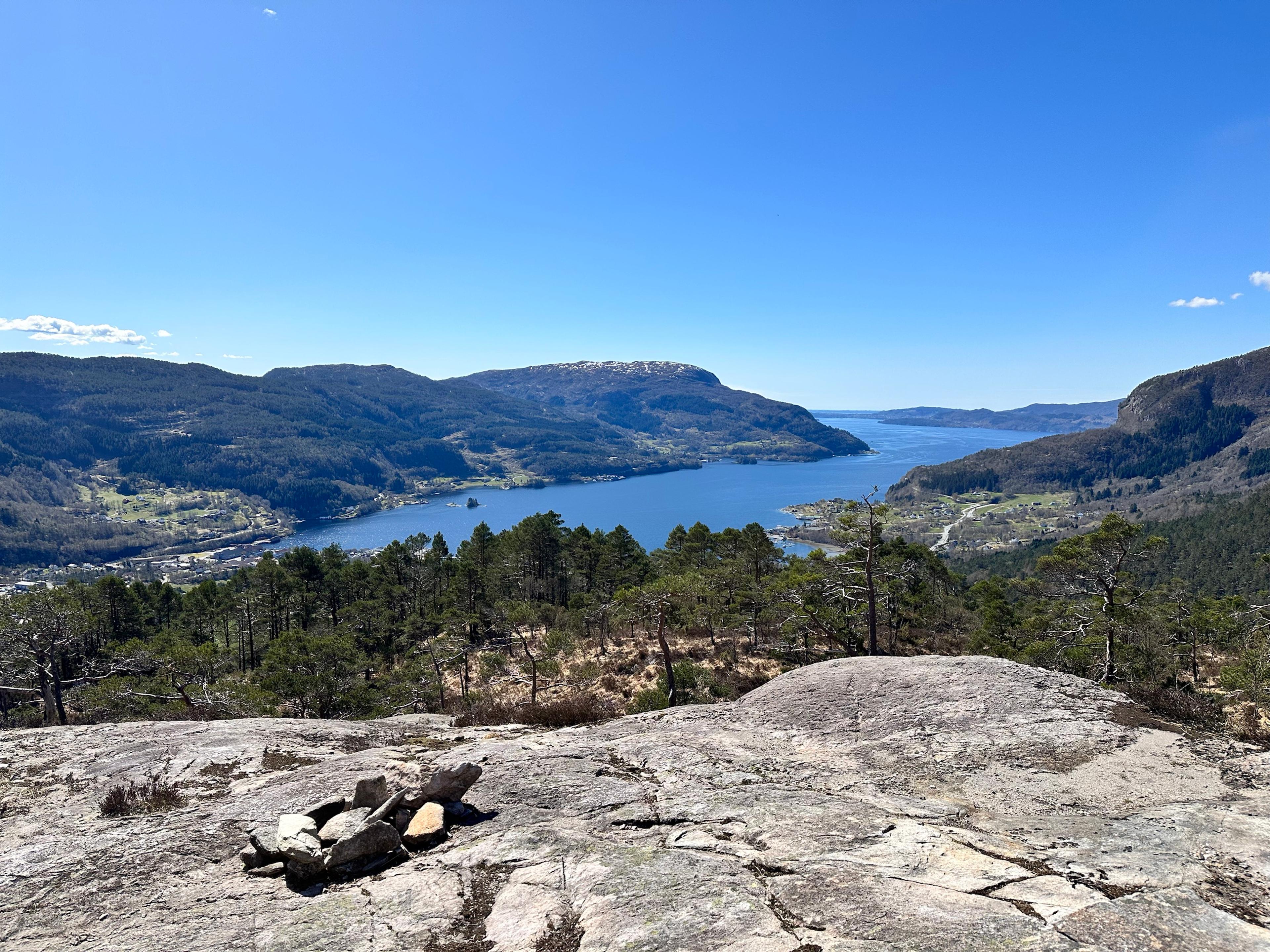 Liten steinvarde på et svaberg, med vid utsikt over fjorden.