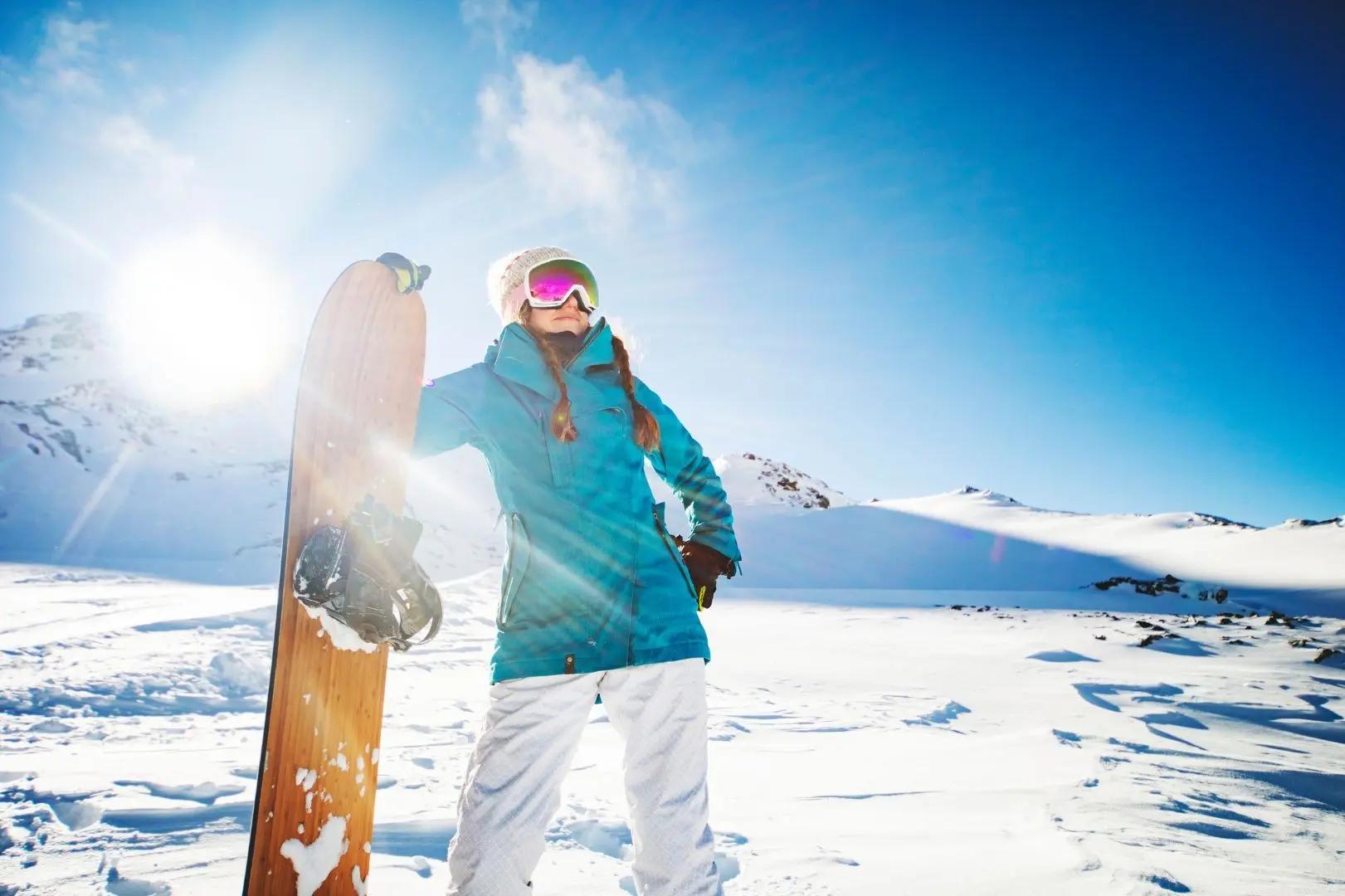 Bilde av kvinne med snowboard på fjellet