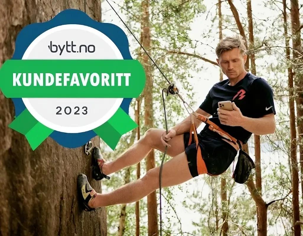 Bilde av Magnus Midtbø i klatrevegg med mobiltelefon i hånden