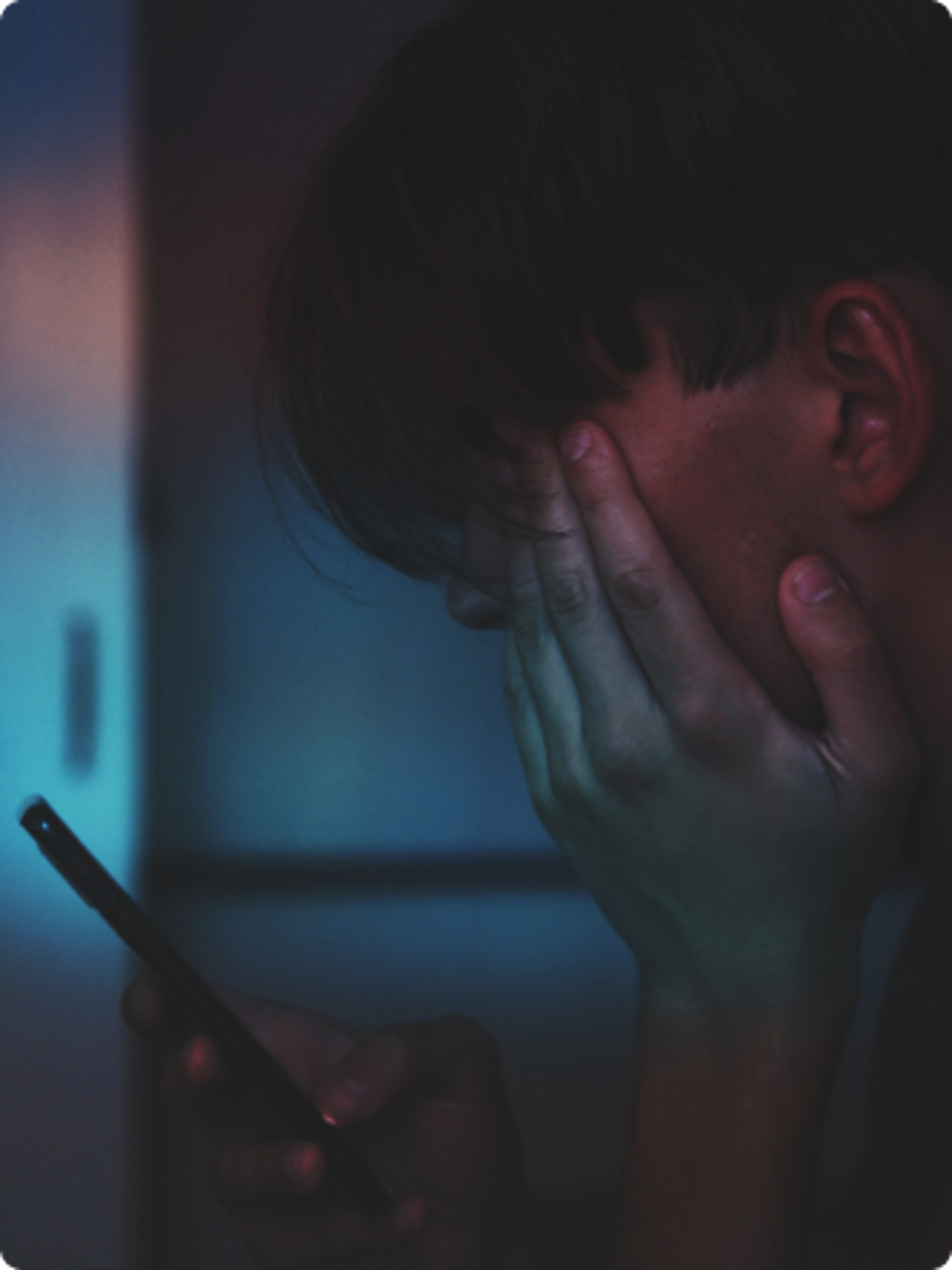 Bilde av ung gutt som holder telefon