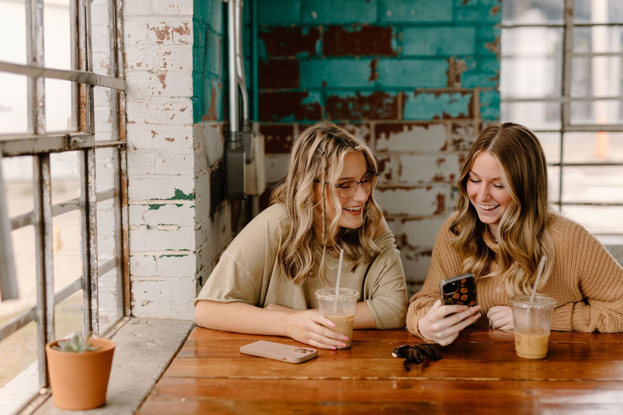 Kvinner på kafé som ser på en mobiltelefon