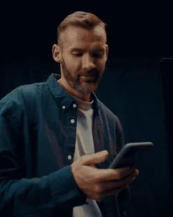 Bilde av mann med skjegg som holder mobil