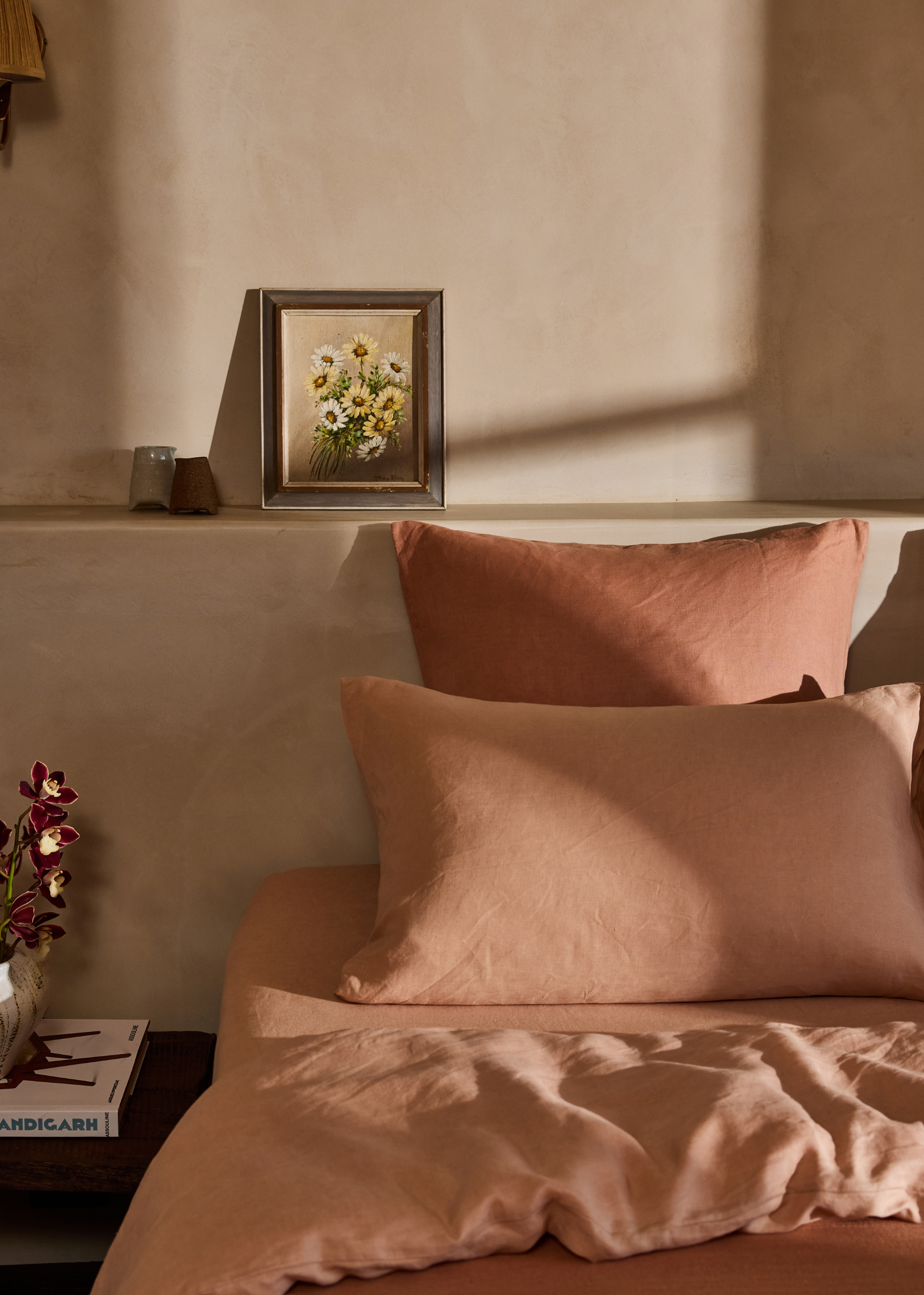 A close up of a bed with rust coloured sheets on it