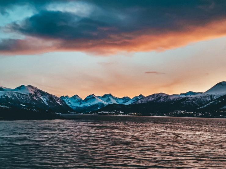 Kveldssol over fjord og fjell i Ålesund - omgitt av naturen som gjør byen til et av Norges vakreste steder å jobbe som veterinær.