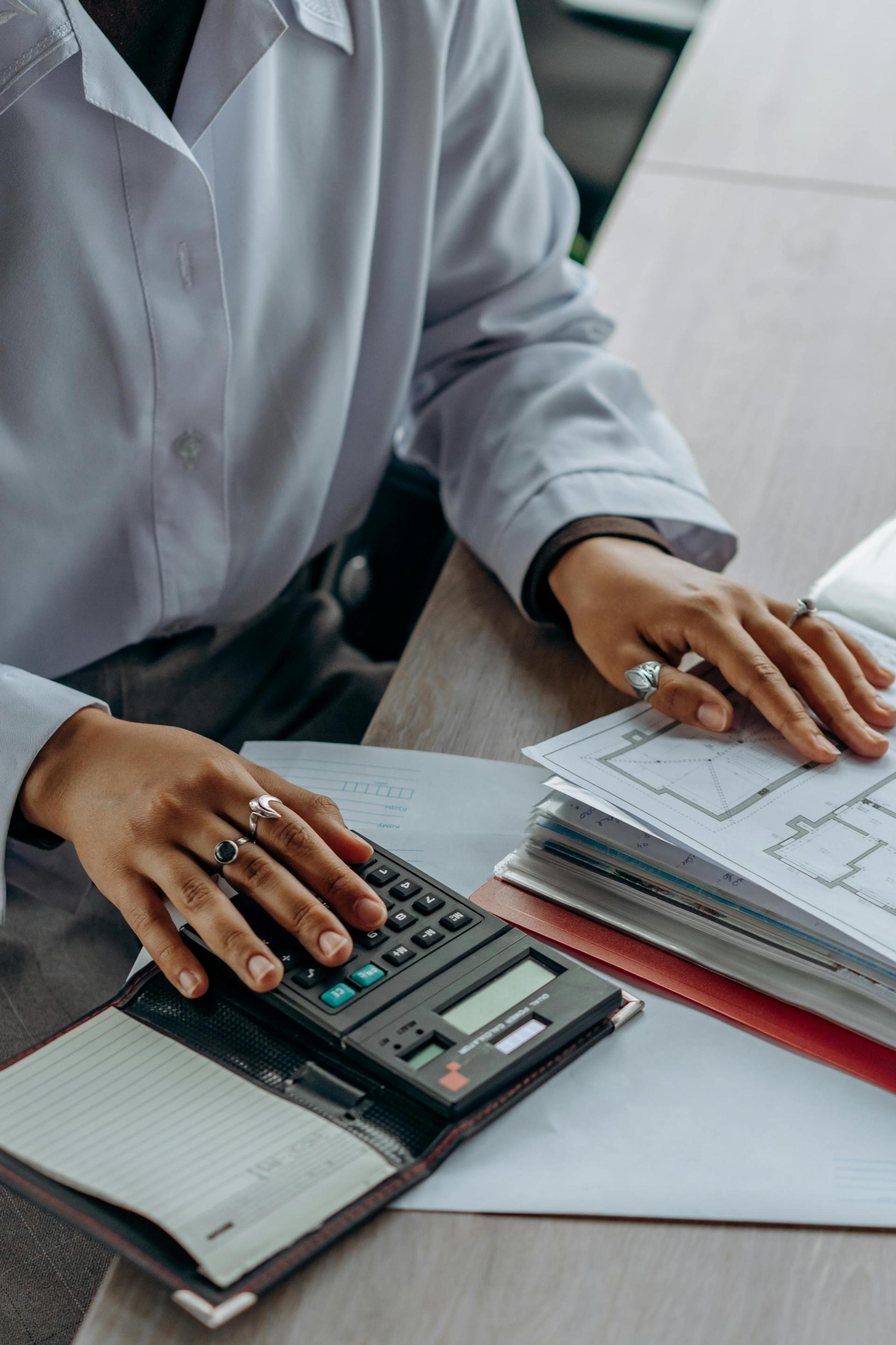 Accountant calculating finances with calculator and tax documents on a desk
