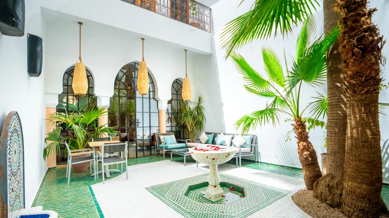 Courtyard fountain, palms and mint-coloured cushions