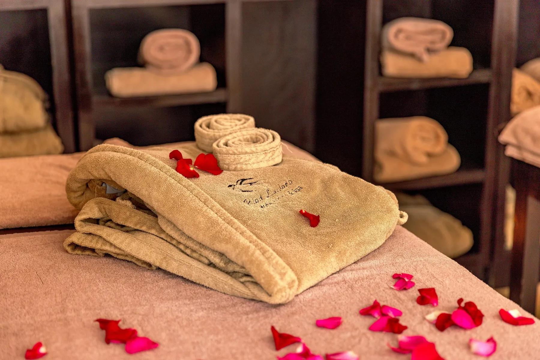 Towels and rose petals prepared for a spa ritual