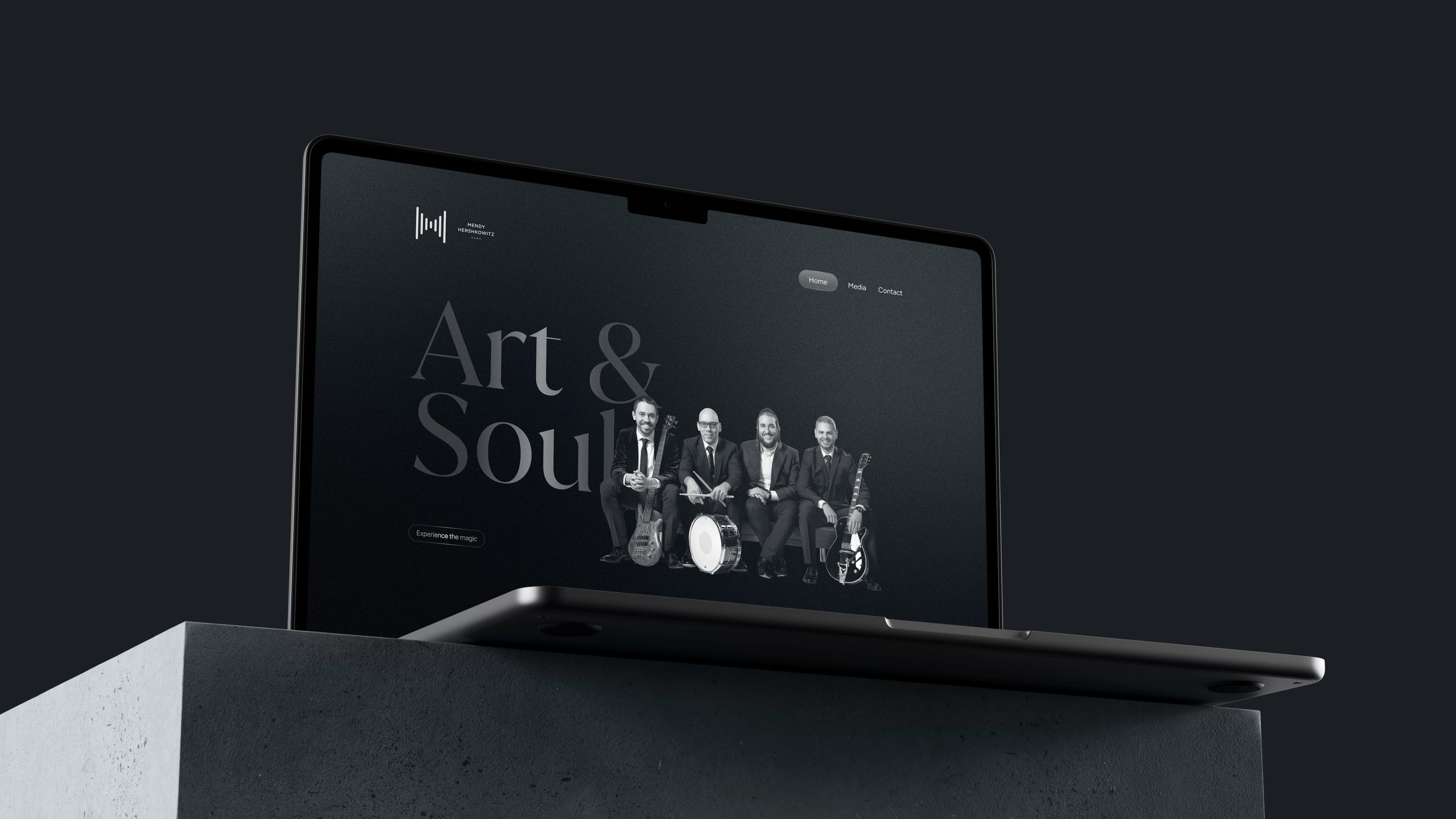 Mendy Hershkowitz Band: Dark music website homepage displayed on a laptop.