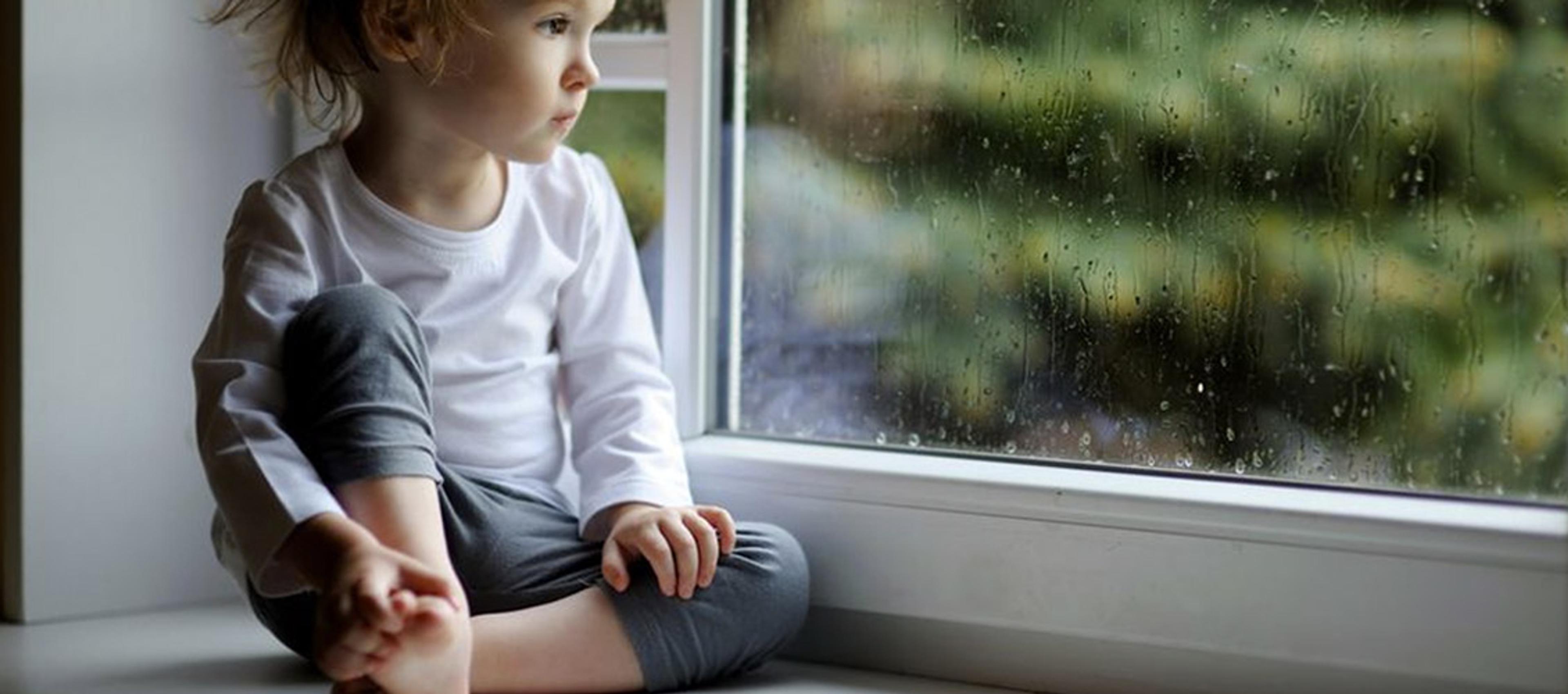 Barn som ser ut av vinduet