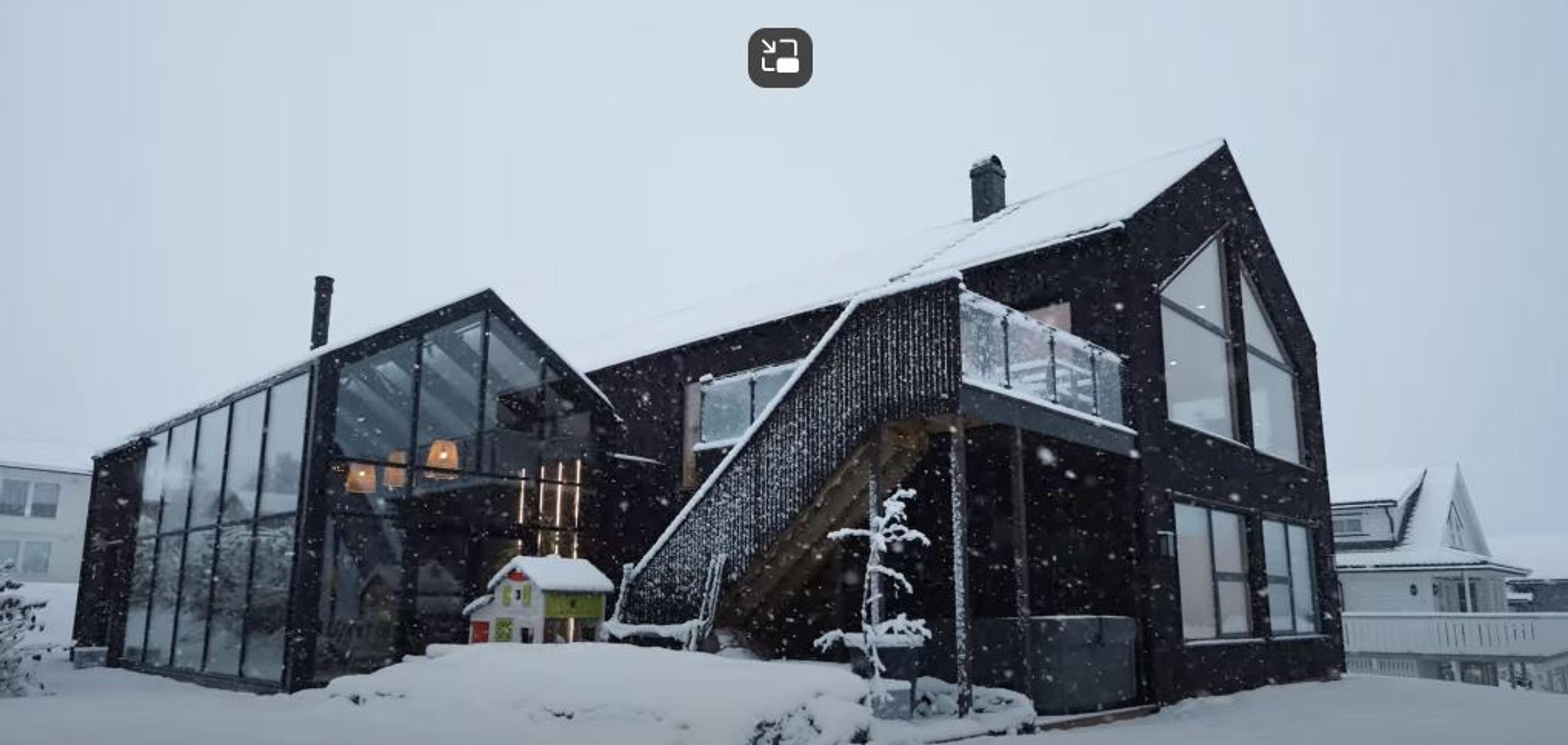 Moderne hus med orangeri i vinterlandskap