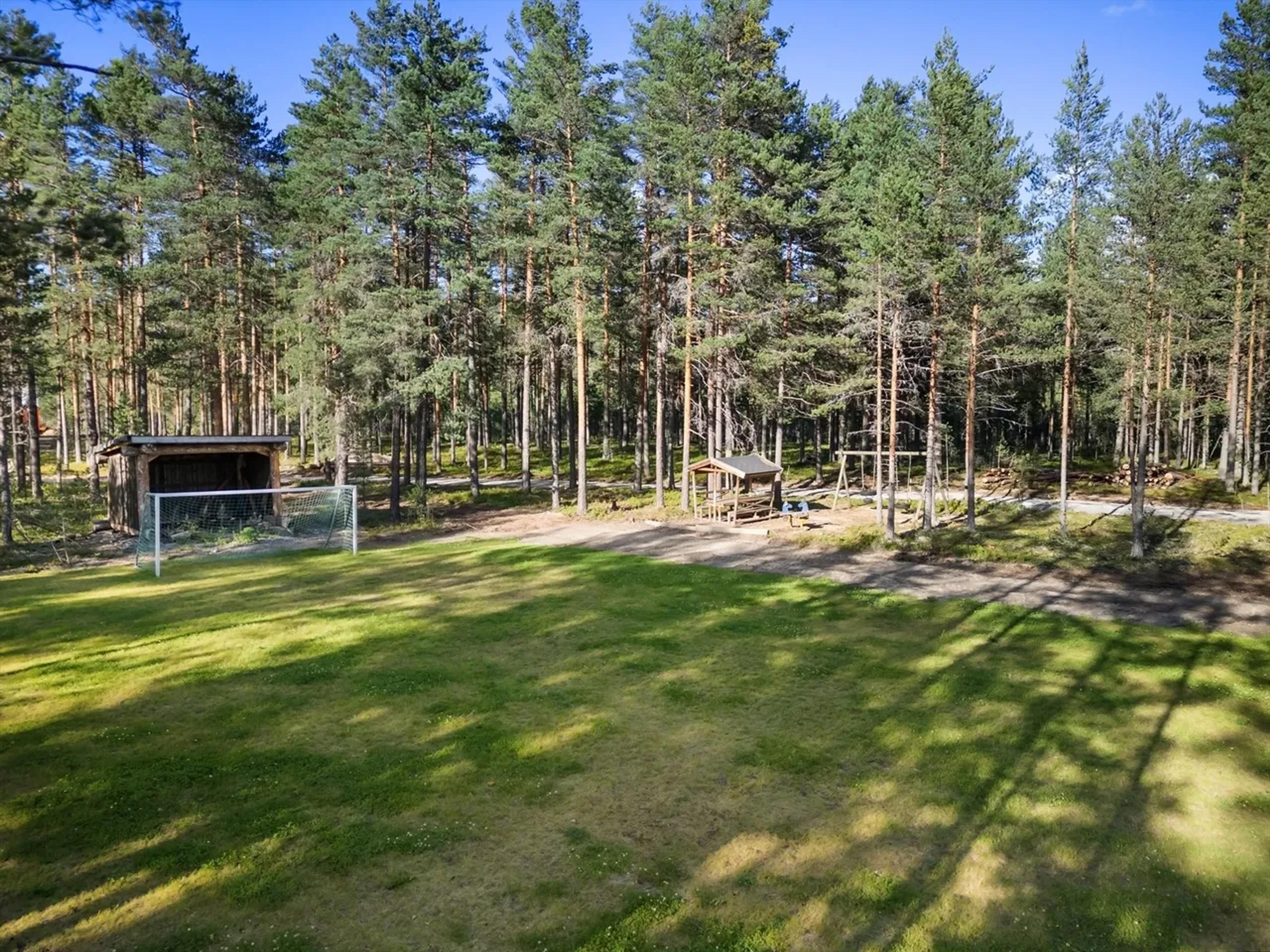 Fotballbane med lekeplass i bakgrunn
