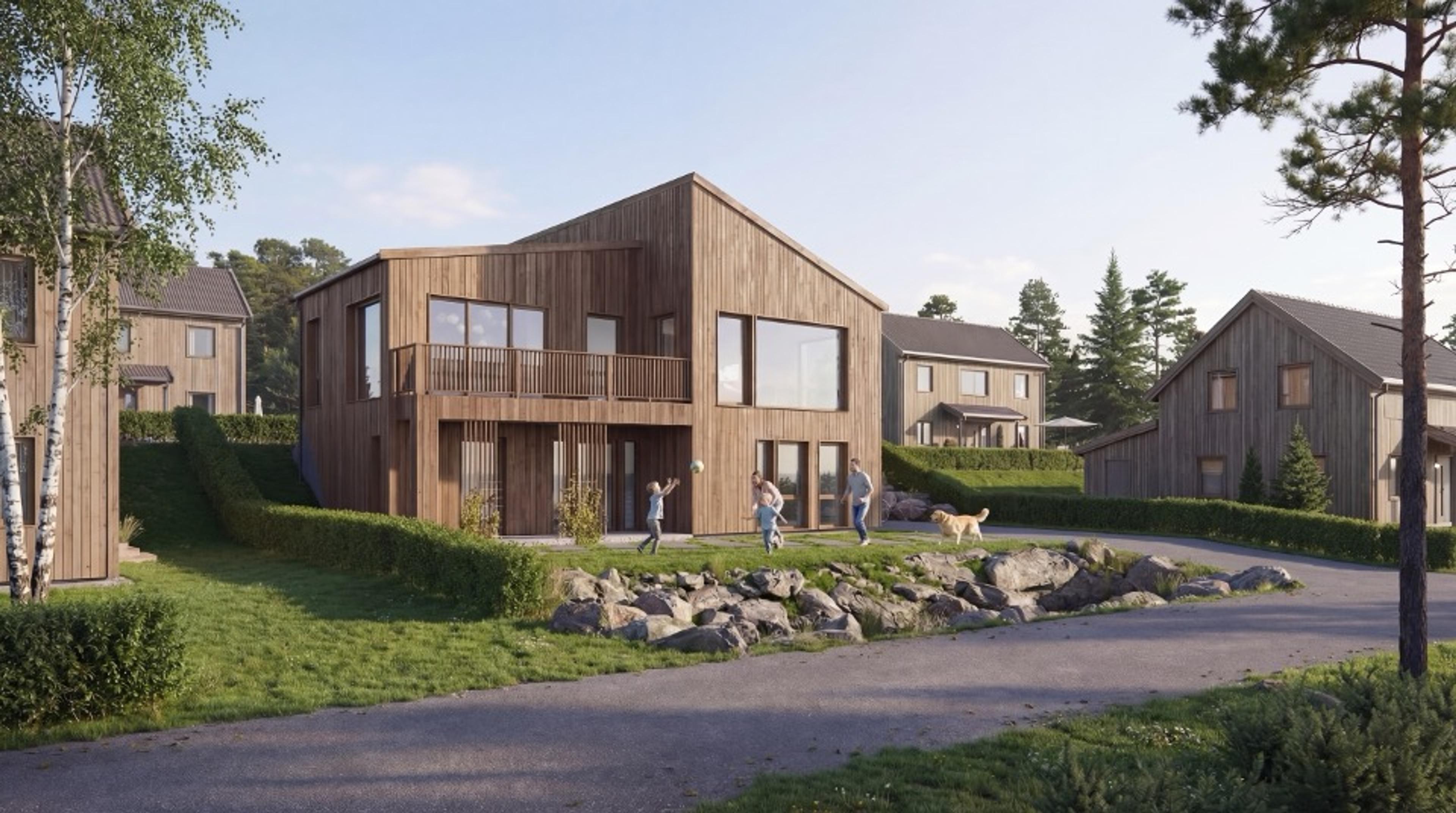 Familie leker i hagen utenfor en moderne enebolig