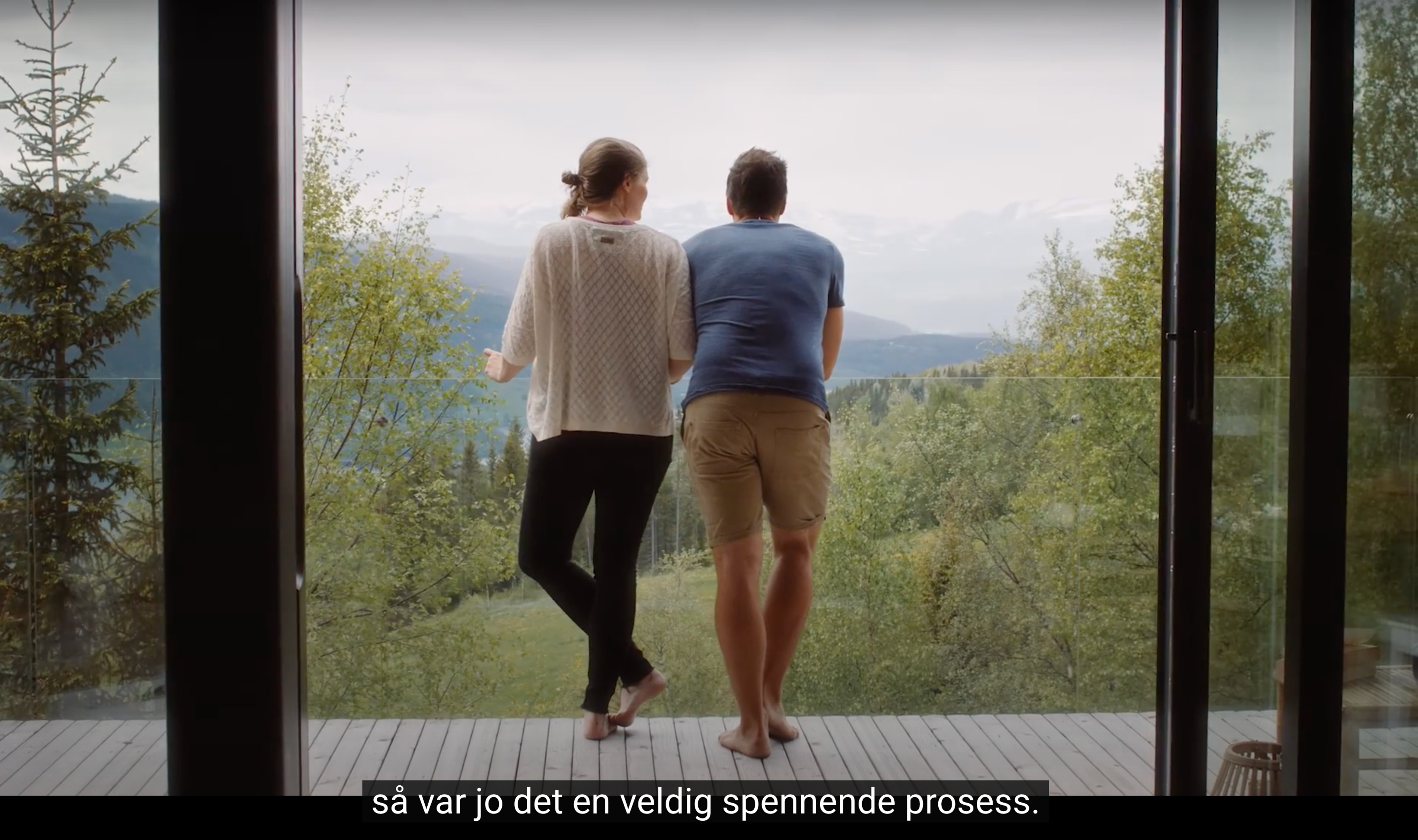 Et par som står på balkongen og ser på utsikten