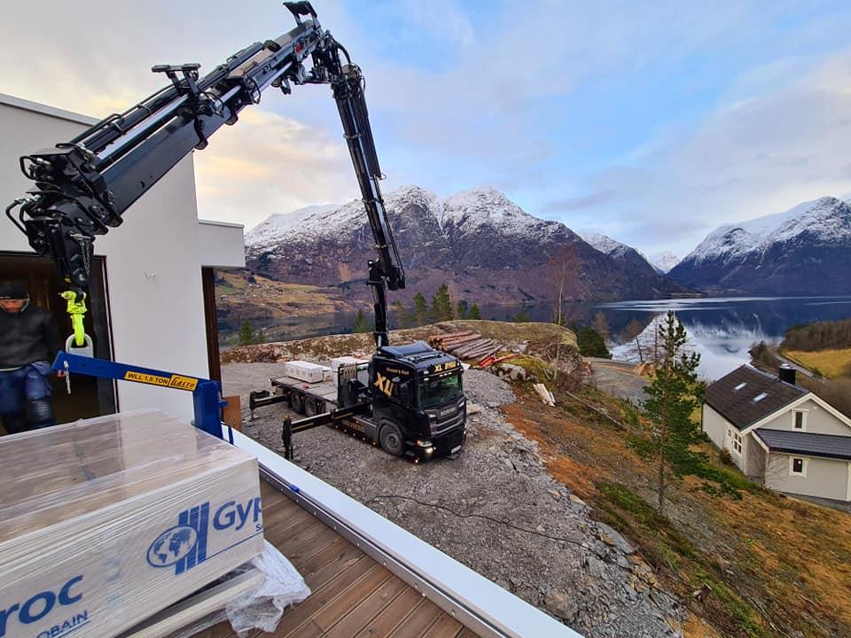 Kranbilen er i gang. Nydelig utsikt med fjellet i bakgrunnen